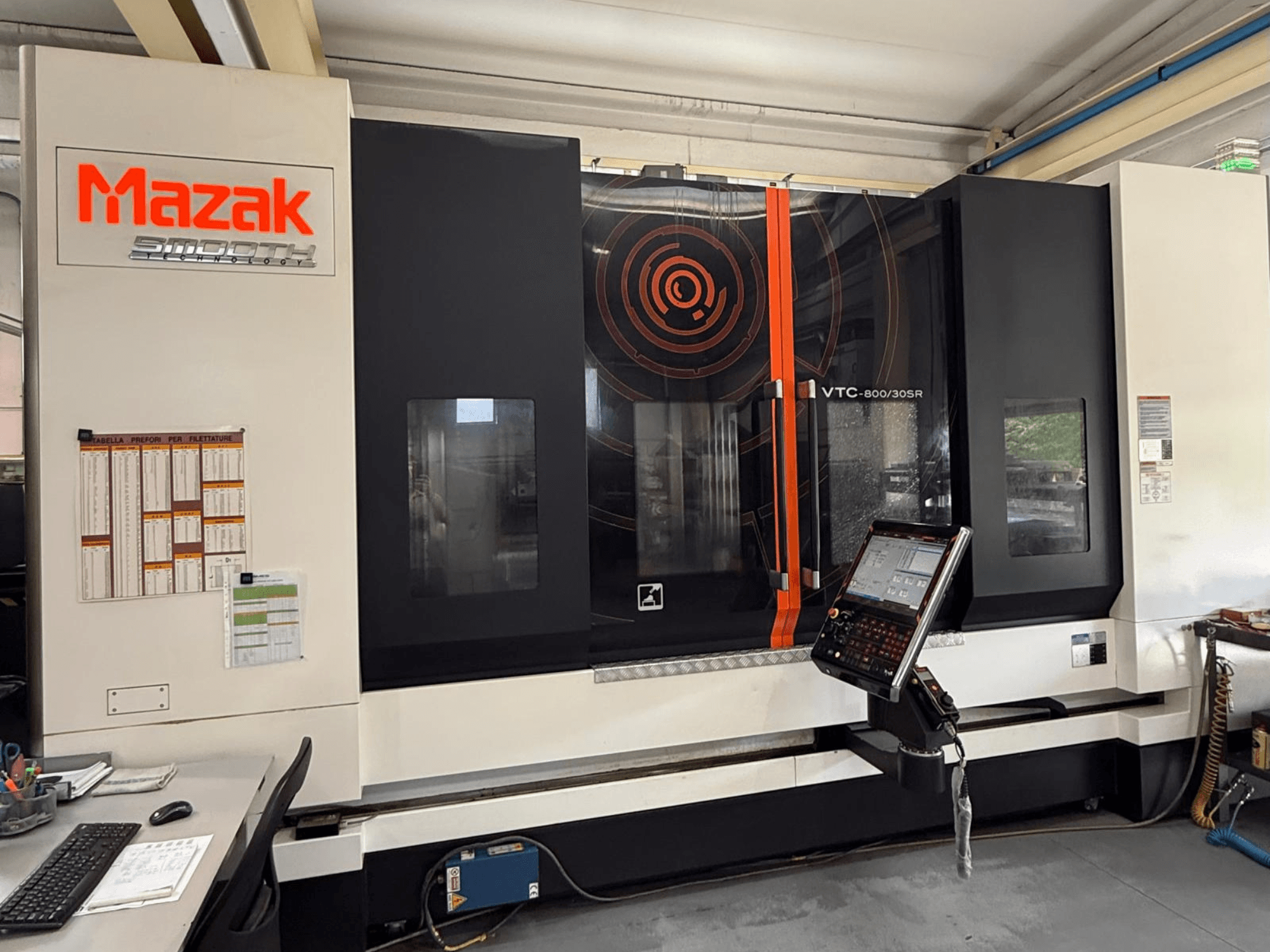 Вертикальный обрабатывающий центр Mazak VTC-800/30SR, вид спереди с панелью управления, дисплеем и рабочей зоной.