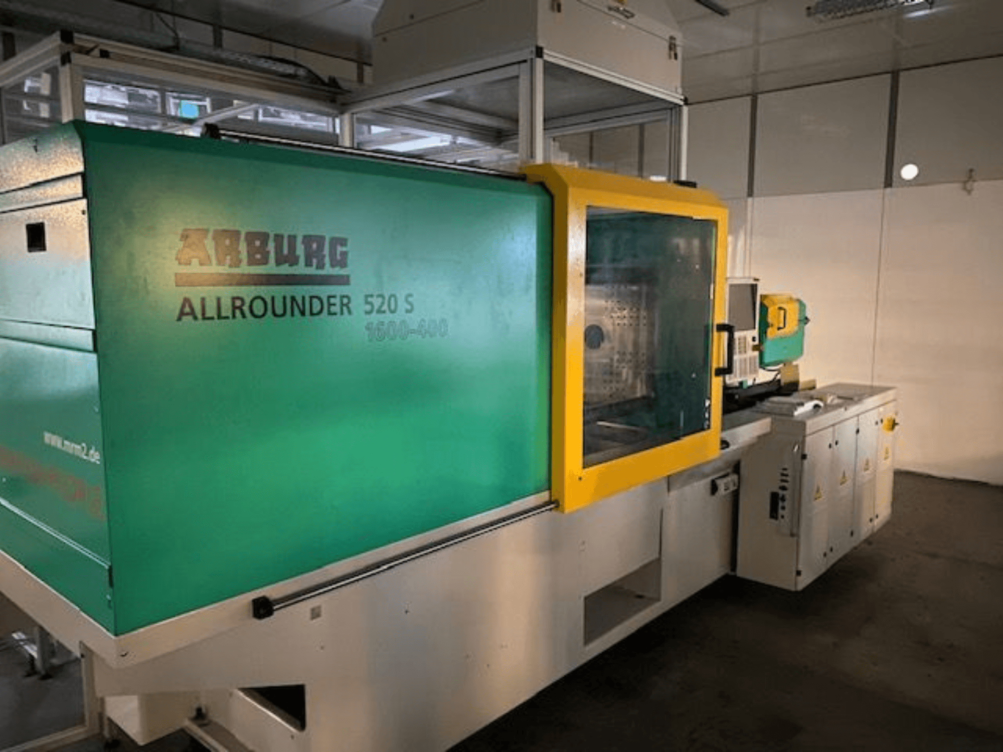 Термопластавтомат Arburg Allrounder 520 S, вид сбоку, внешний вид зеленого и желтого цвета, видны технические детали.