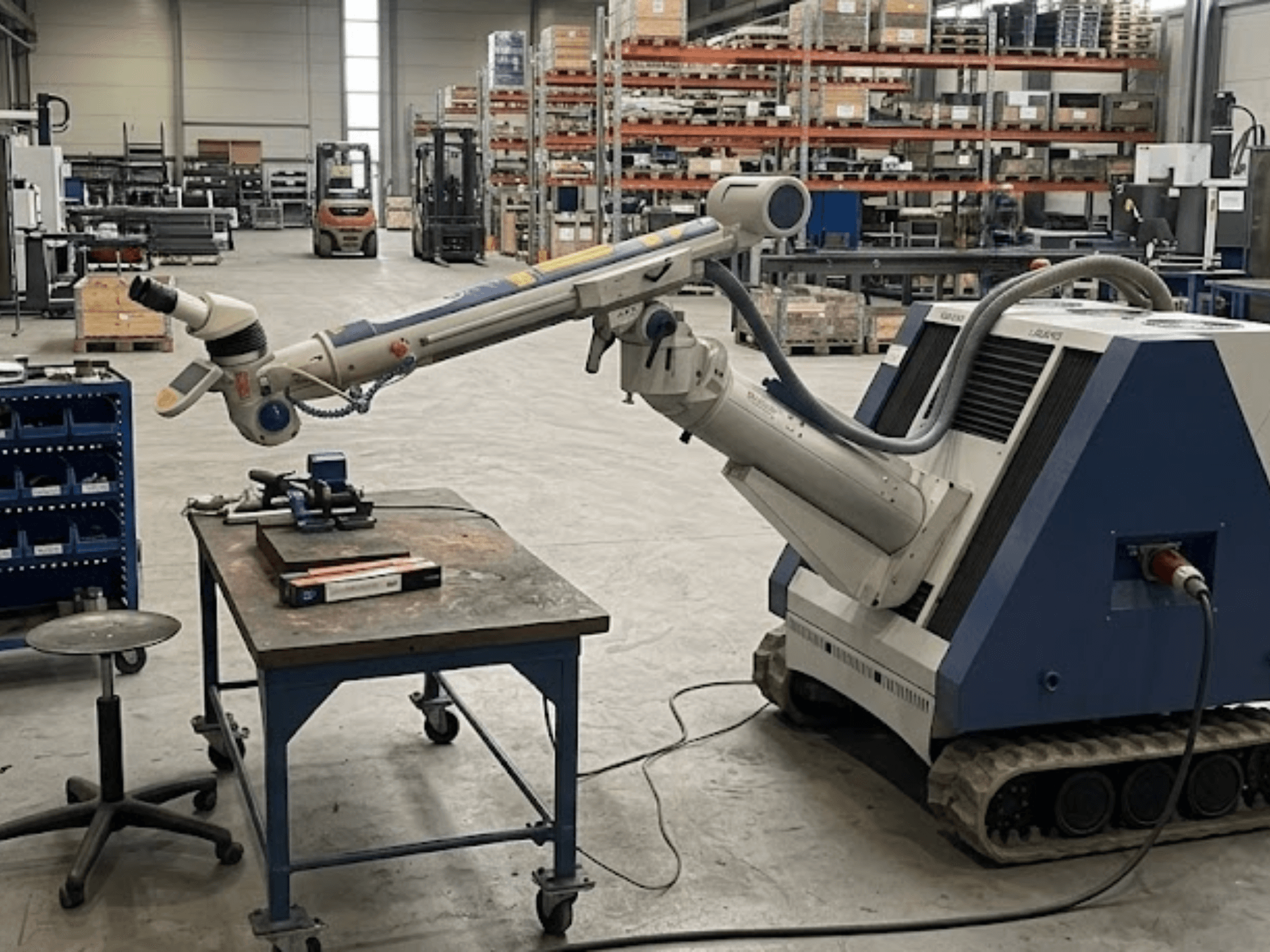 Станк ALPHA LASER ALFlak300 M в цехе с роботом-манипулятором, вид спереди, демонстрирующий точную настройку на рабочем столе.