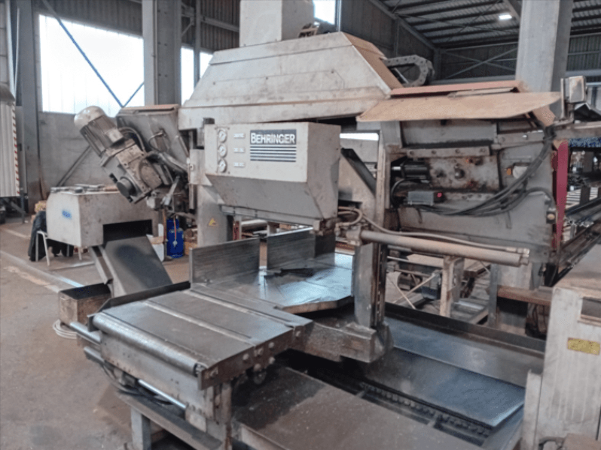 Ленточная пила Behringer, вид спереди, оснащена большим полотном, двигателем и регулируемым столом, идеально подходит для резки металла в мастерской.