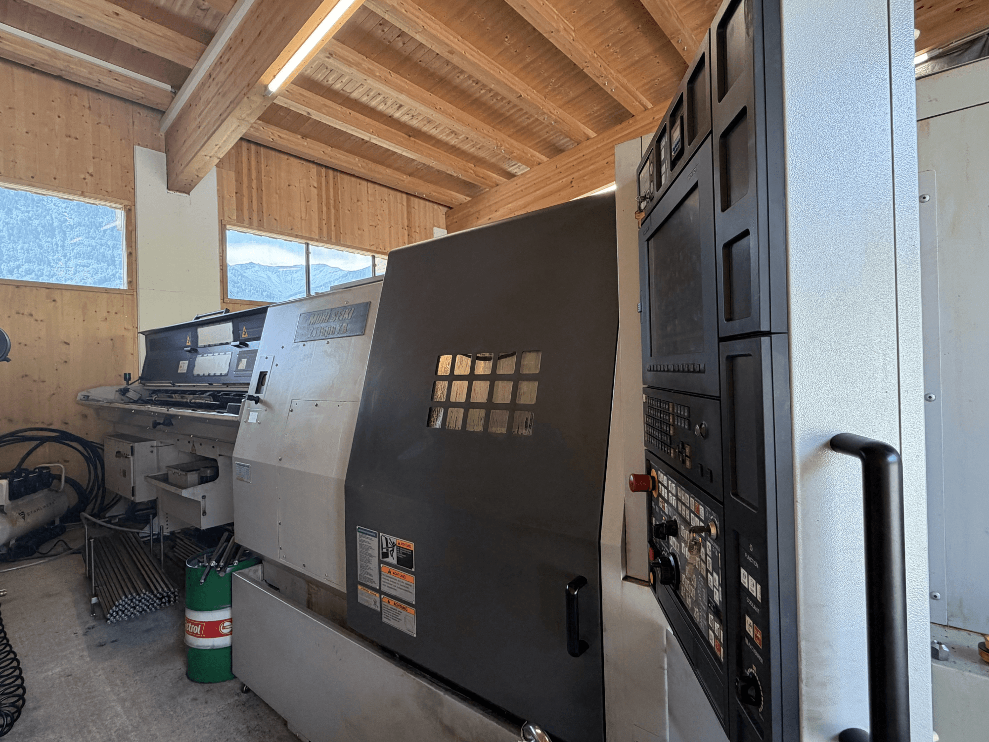 Токарно-фрезерный центр MORI SEIKI ZT1500YB в цехе, вид сбоку, на котором видны панель управления и конструктивные особенности станка.