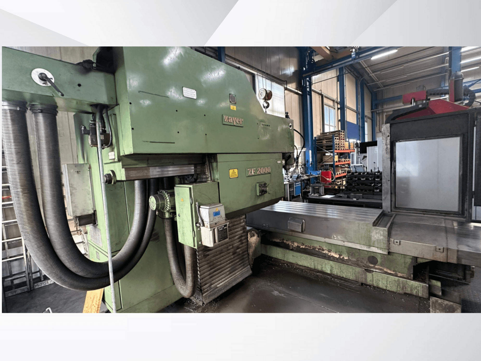 Фрезерный станок Zayer ZF 2000 зеленого цвета, вид сбоку на панель управления и большую фрезерную станину с присоединенными шлангами.