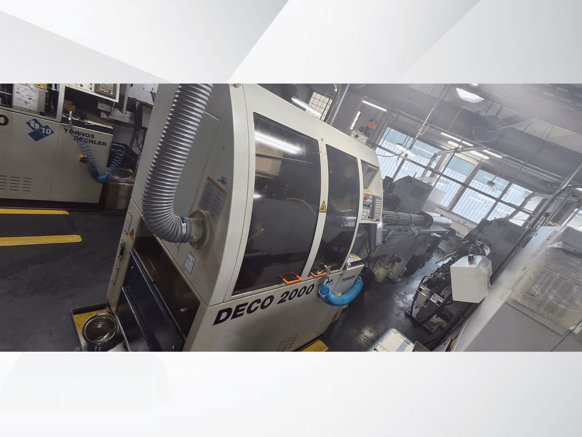 Станок с ЧПУ DECO 2000 в мастерской, вид спереди, вентиляционный шланг и панель управления, предназначен для точной обработки.