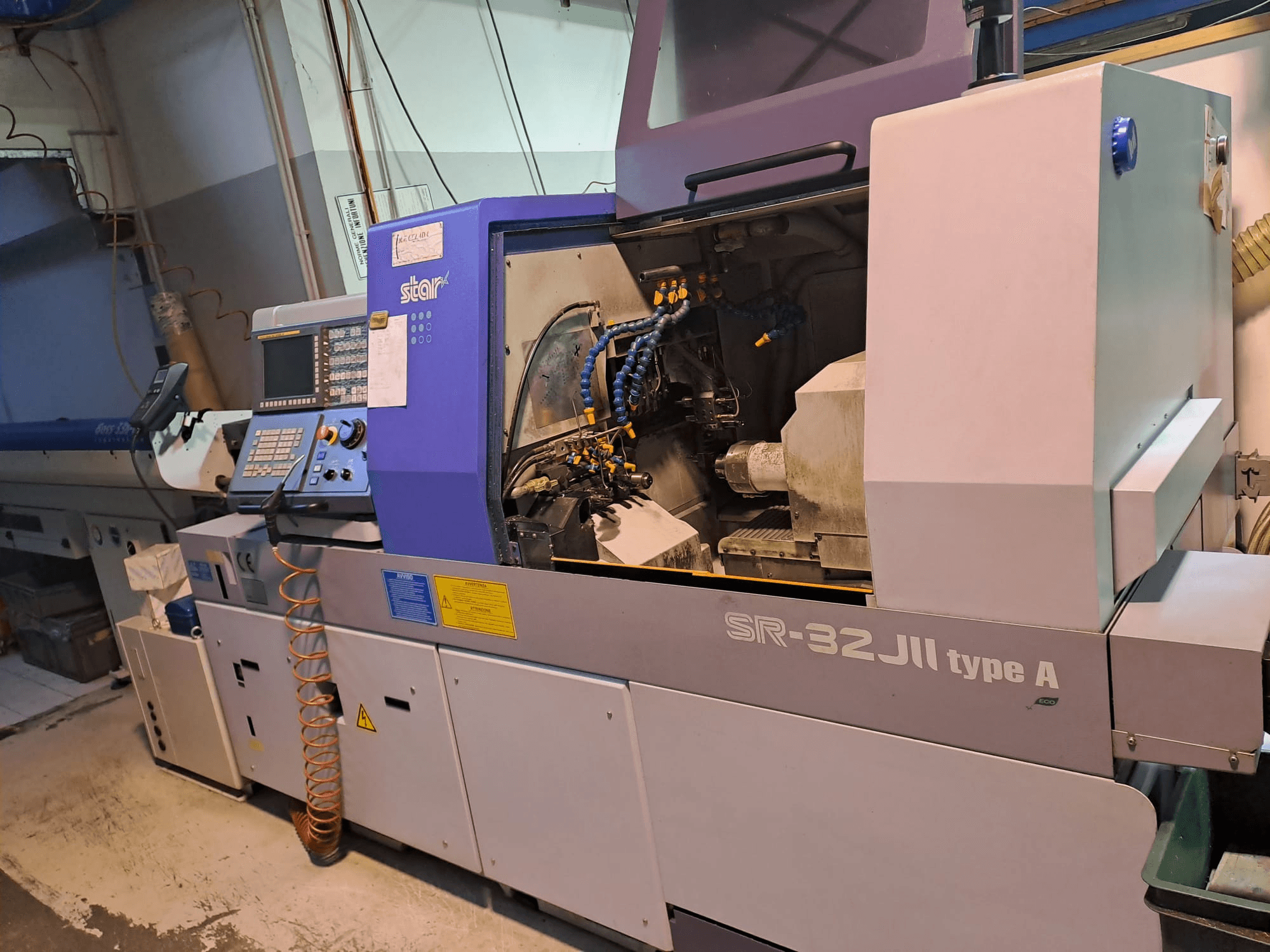 STAR MICRONICS SR-32JII-typeA Токарный станок швейцарского типа вид сбоку, панель управления и видимые компоненты обработки.