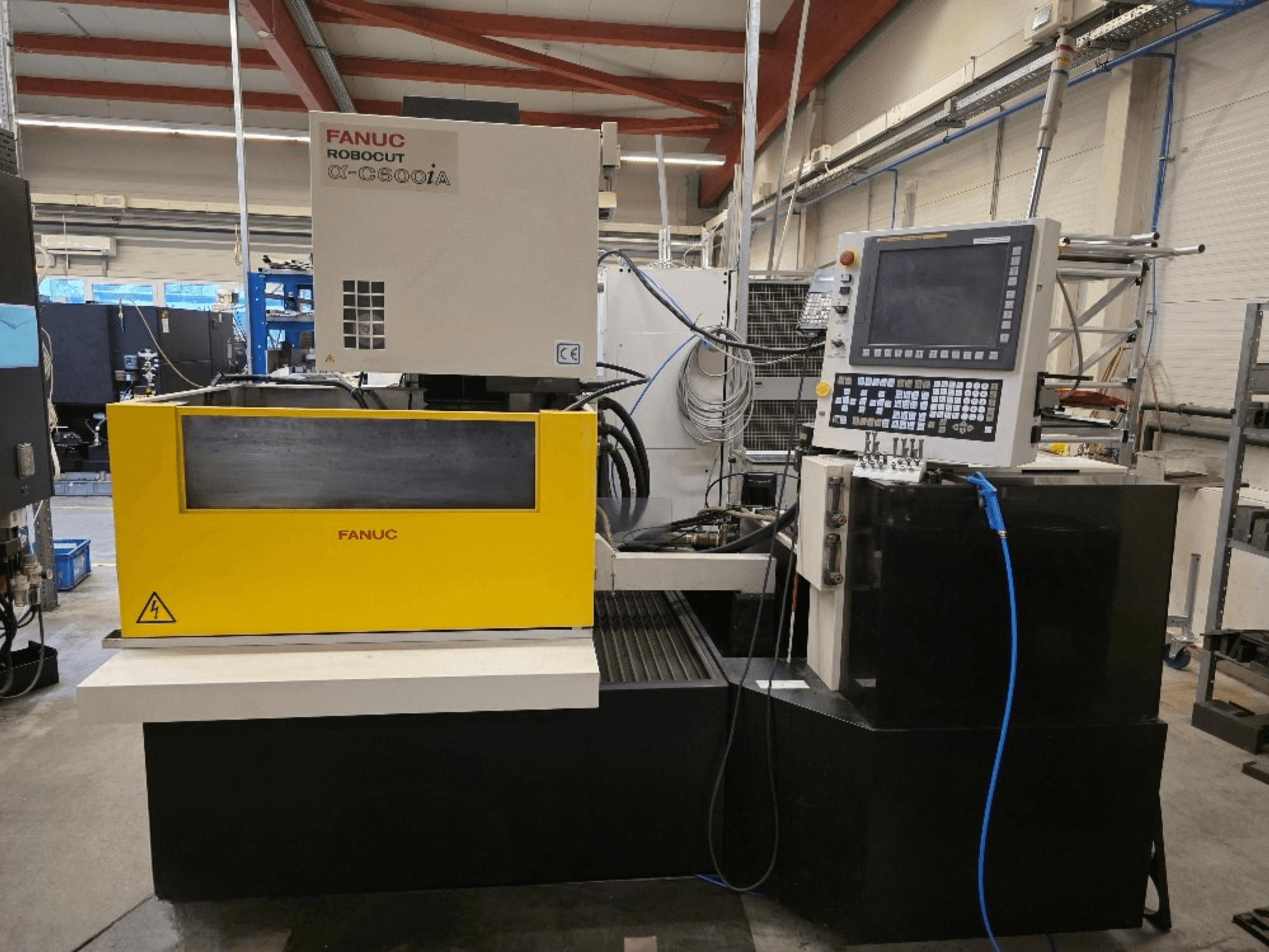 Проволочно-вырезной станок FANUC Robocut α-C600iA, вид спереди, с желтой панелью управления и цифровым дисплеем.