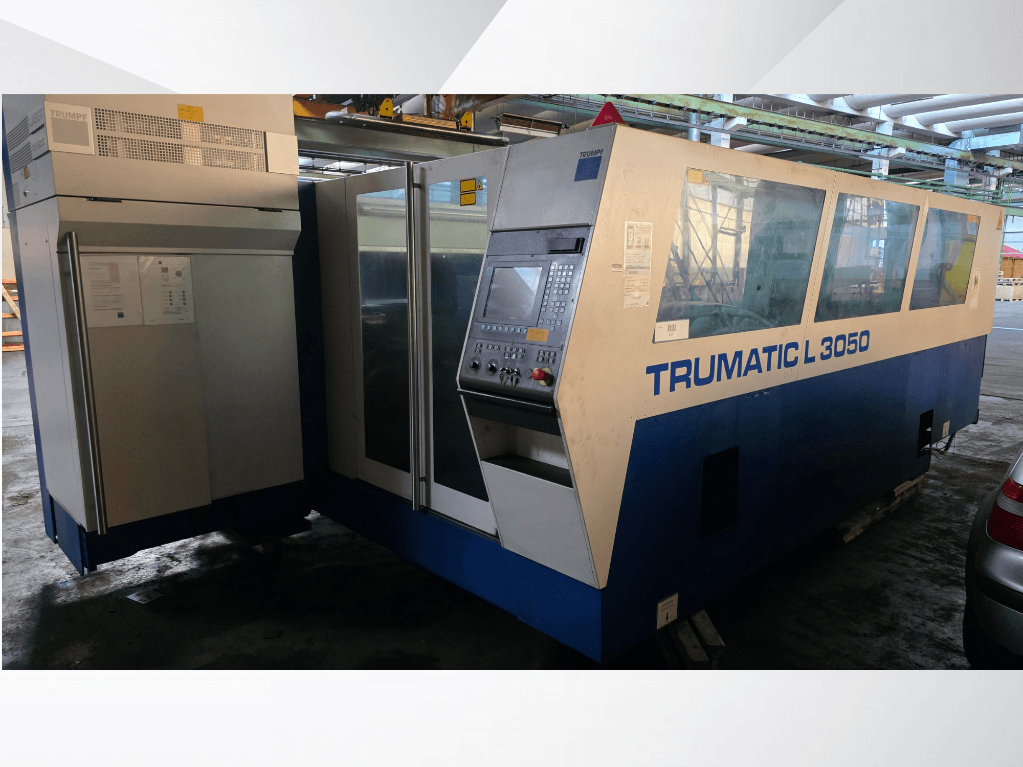 Станок лазерной резки CO2 TRUMPF Trumatic L 3050, вид спереди, с панелью управления и большими стеклянными окнами.