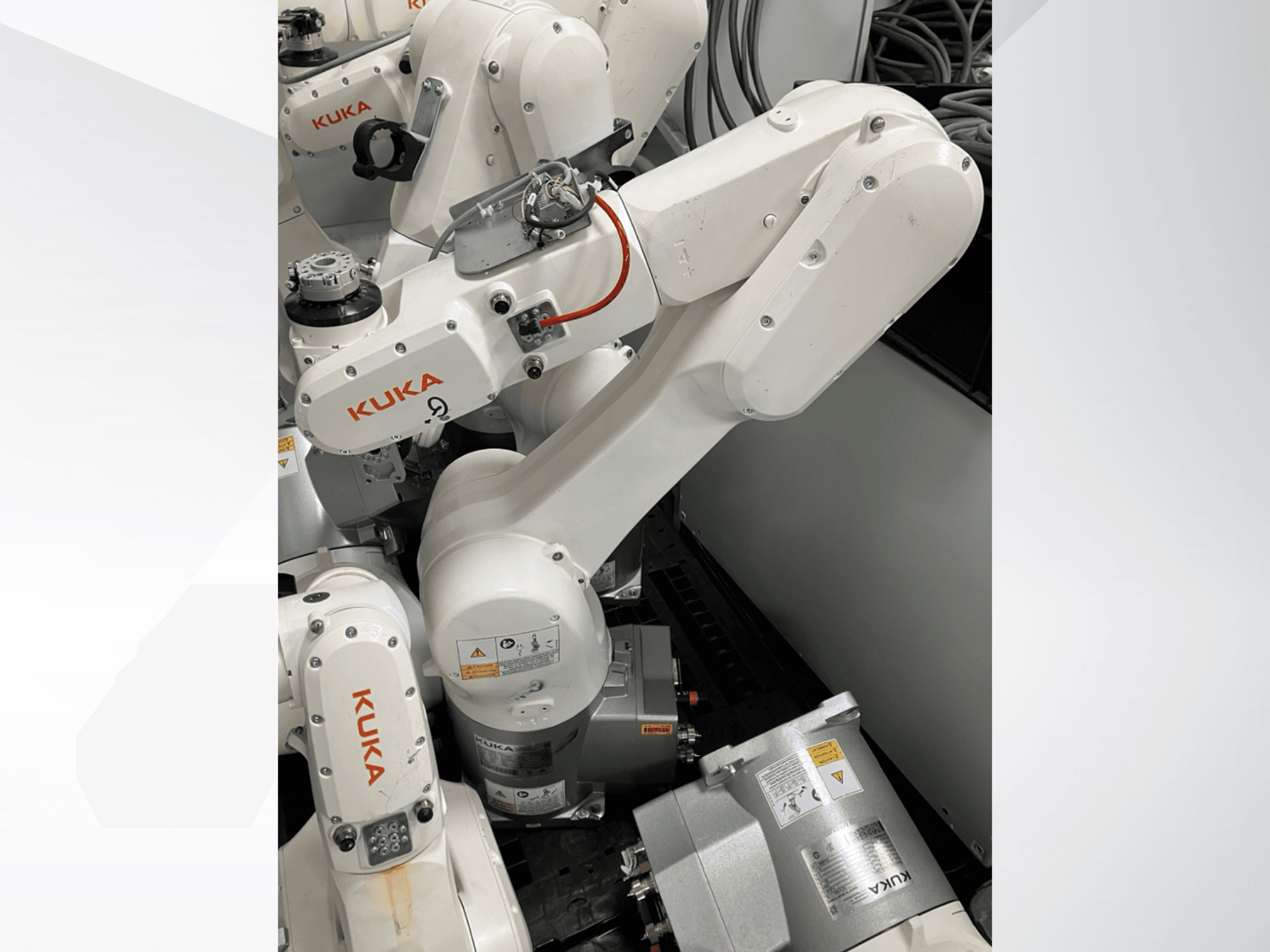 Рука робота KUKA KR 6 R900 CR, вид сбоку; видны двигатели и разъемы, предупреждающие надписи и механические манипуляторы.