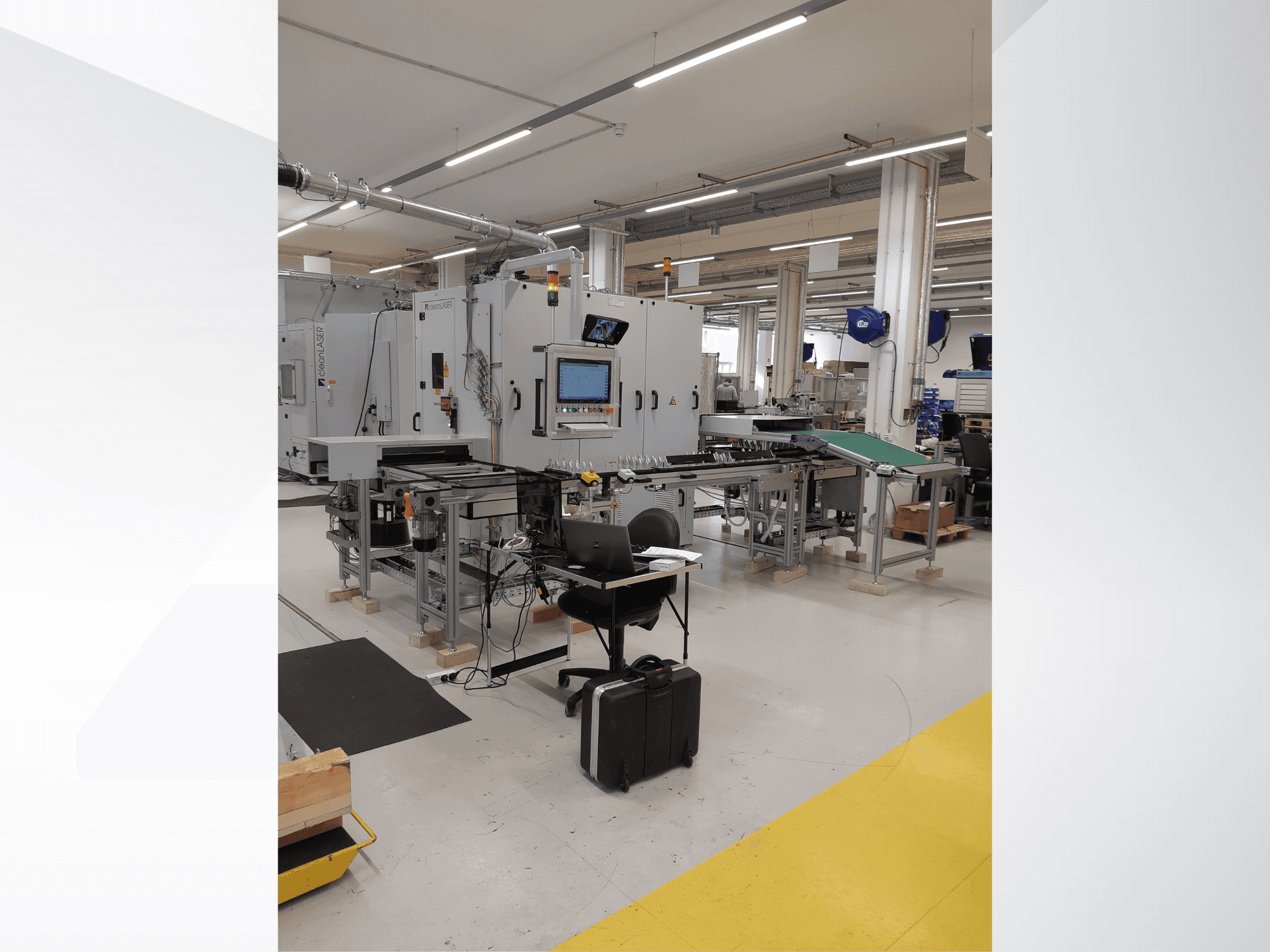 Станок CLEAN LASER clean CELL 3220, вид спереди с панелью управления, конвейером и рабочим местом в заводских условиях.