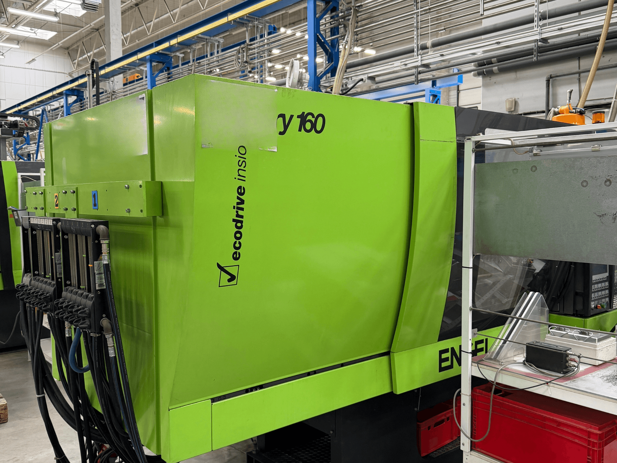 Гидравлический термопластавтомат Engel Victory 500/160 tech зеленого цвета, вид сбоку с панелью управления и функцией ecodrive.
