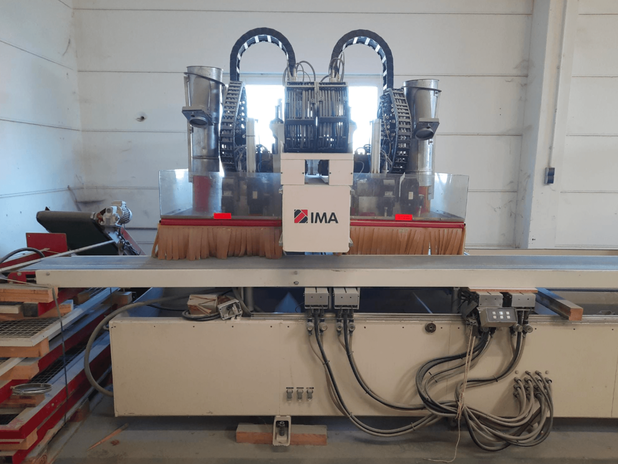 Деревообрабатывающий центр с ЧПУ IMA BIMA 610 V, вид спереди: на фотографии видны щетки, элементы управления и рабочий стол.