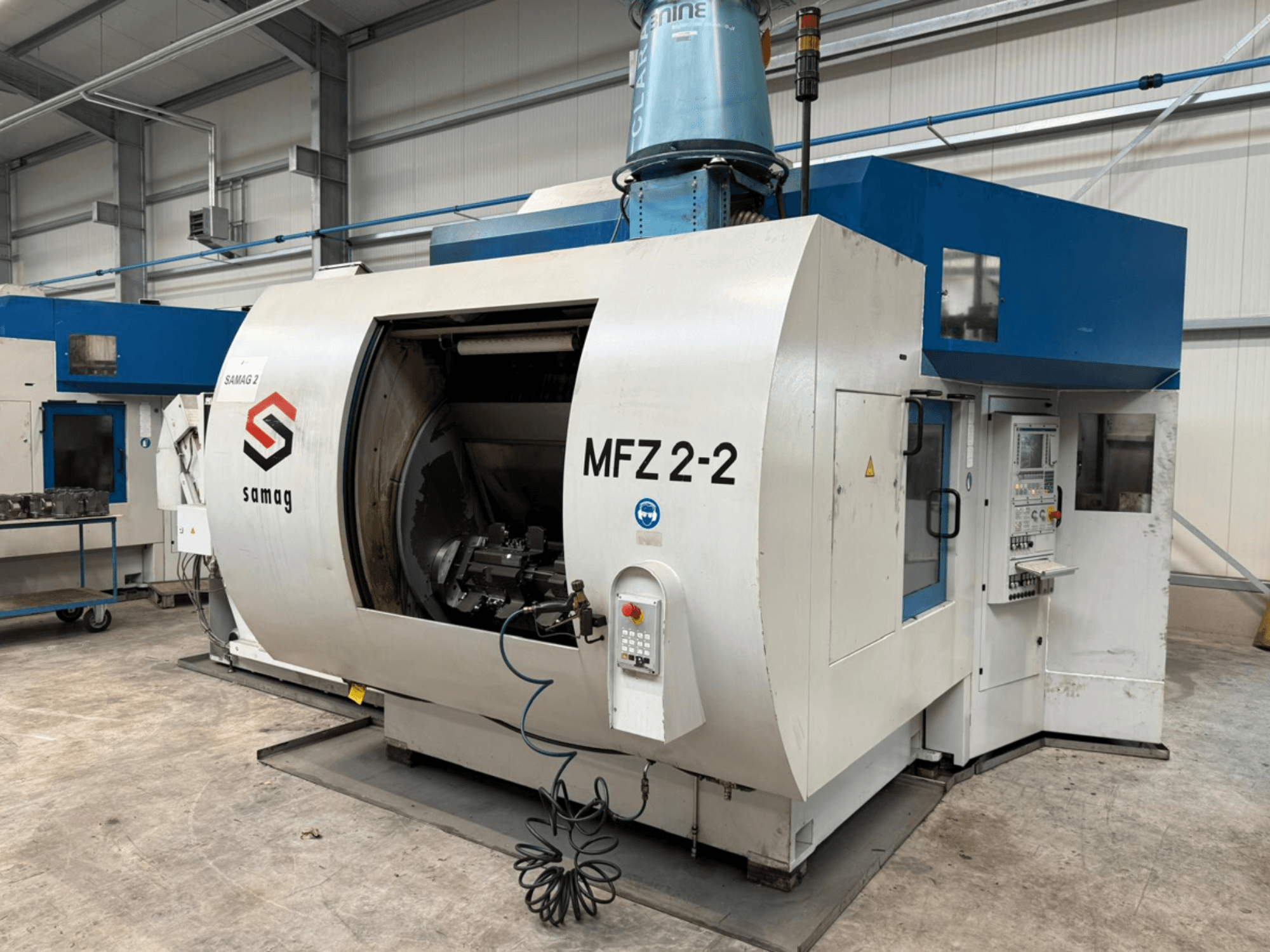 Фрезерный станок Samag MFZ 2-2 вид сбоку, демонстрирующий большую открытую камеру и панель управления с различными кнопками и ручками.