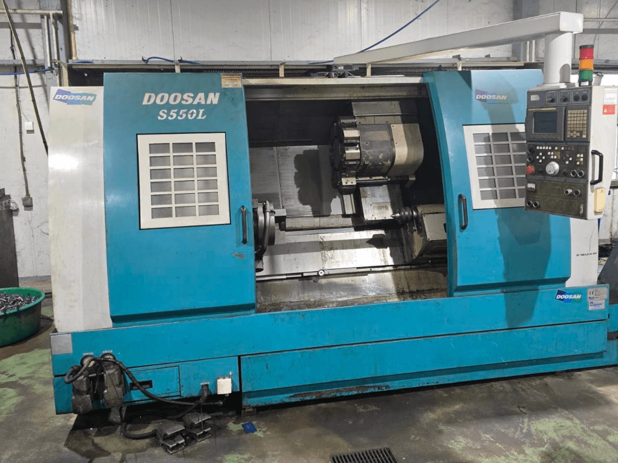 Горизонтальный токарный станок DOOSAN S550L вид сбоку, с панелью управления и токарной станиной, идеально подходит для точной обработки.