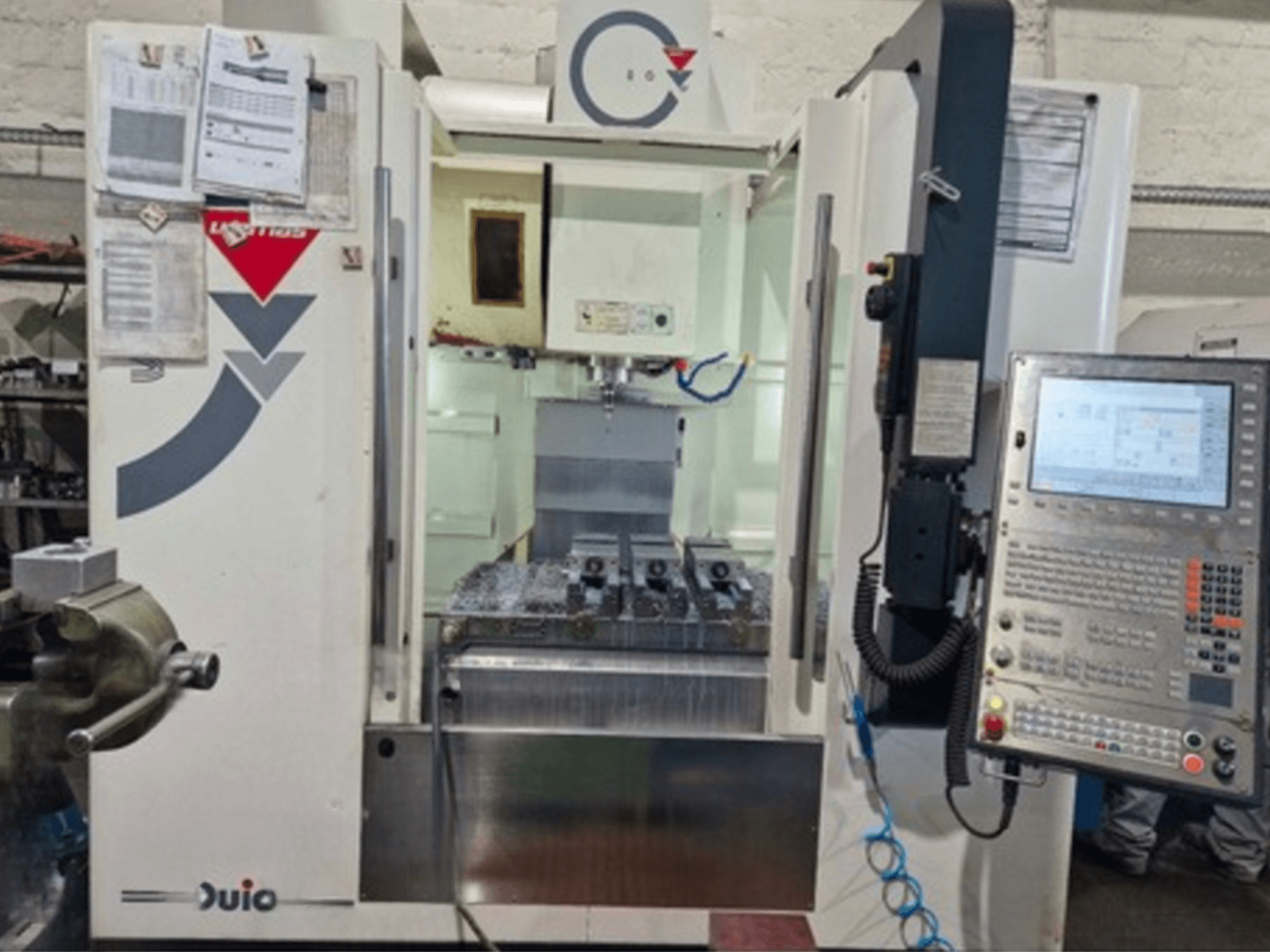 Вид спереди на вертикальный обрабатывающий центр WEMAS VZ 860 с панелью управления и интерфейсом ЧПУ, с приложенными документами.