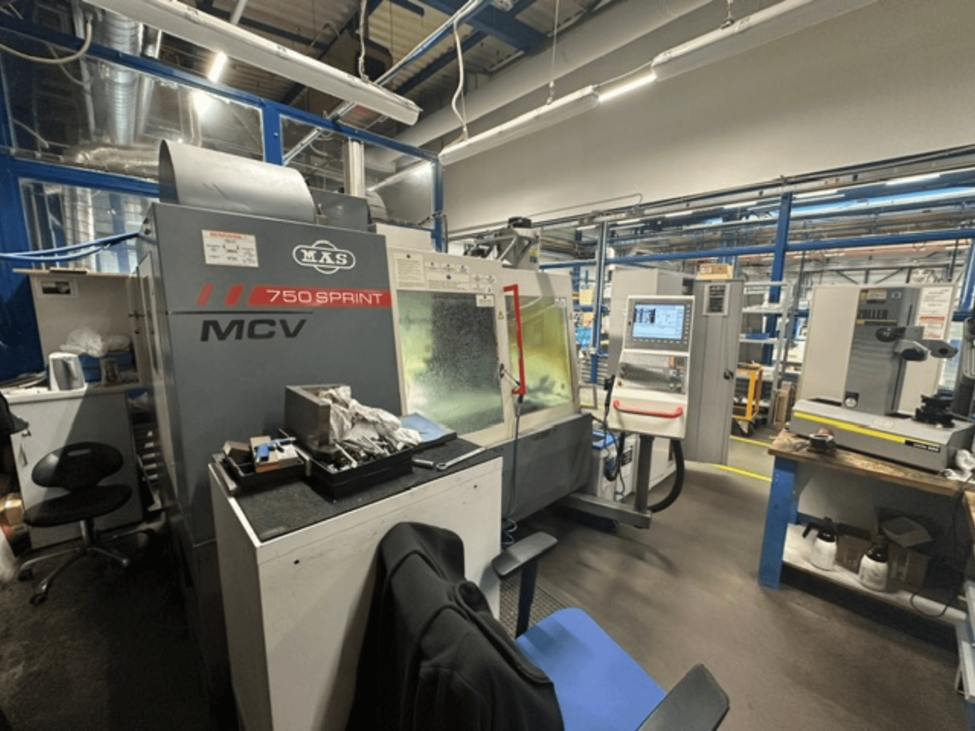 Вертикальный обрабатывающий центр KOVOSVIT MAS MCV 750 Sprint в цехе: вид сбоку на панель управления и рабочую зону.
