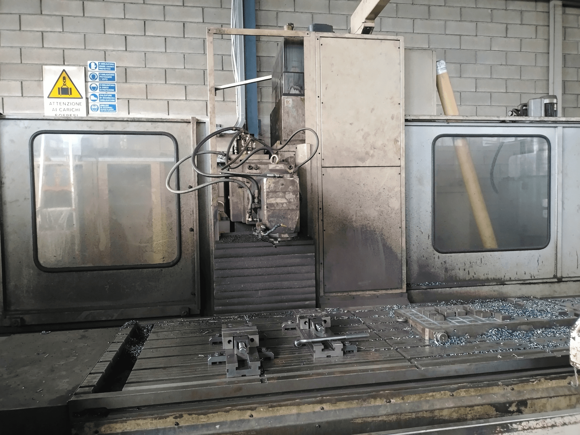 Фрезерный станок TIGER TFA6 со станиной в мастерской, вид спереди, видны инструменты и металлическая стружка на столе.