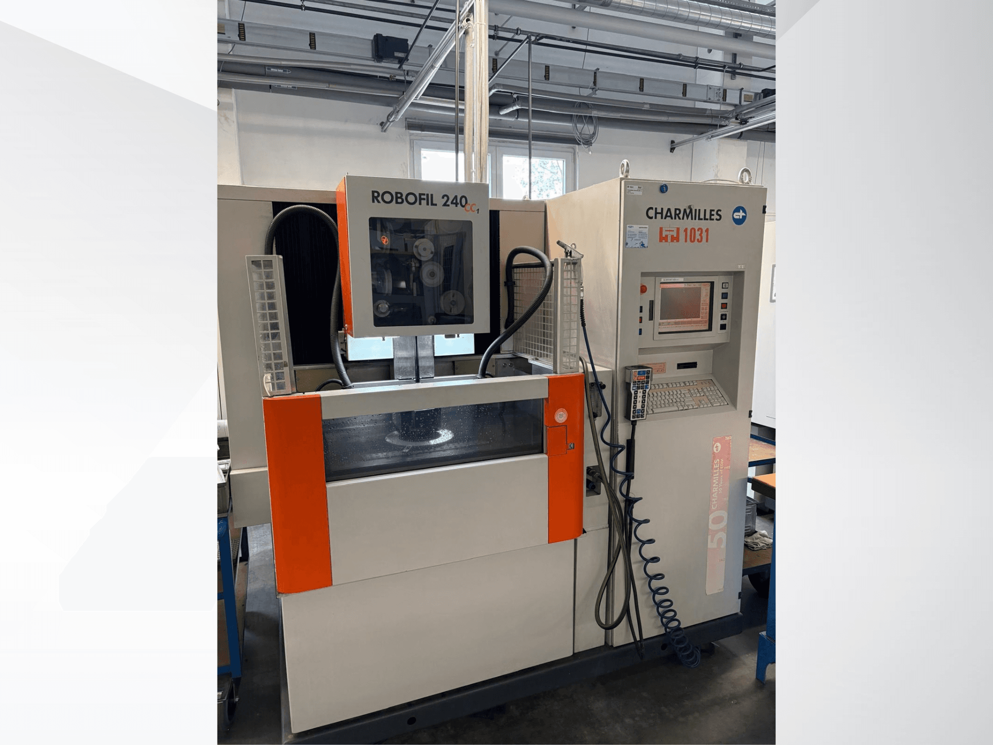 Электроэрозионный станок CHARMILLES Robofil 240 CC, вид спереди с панелью управления и резервуаром для воды, с яркими оранжевыми акцентами.