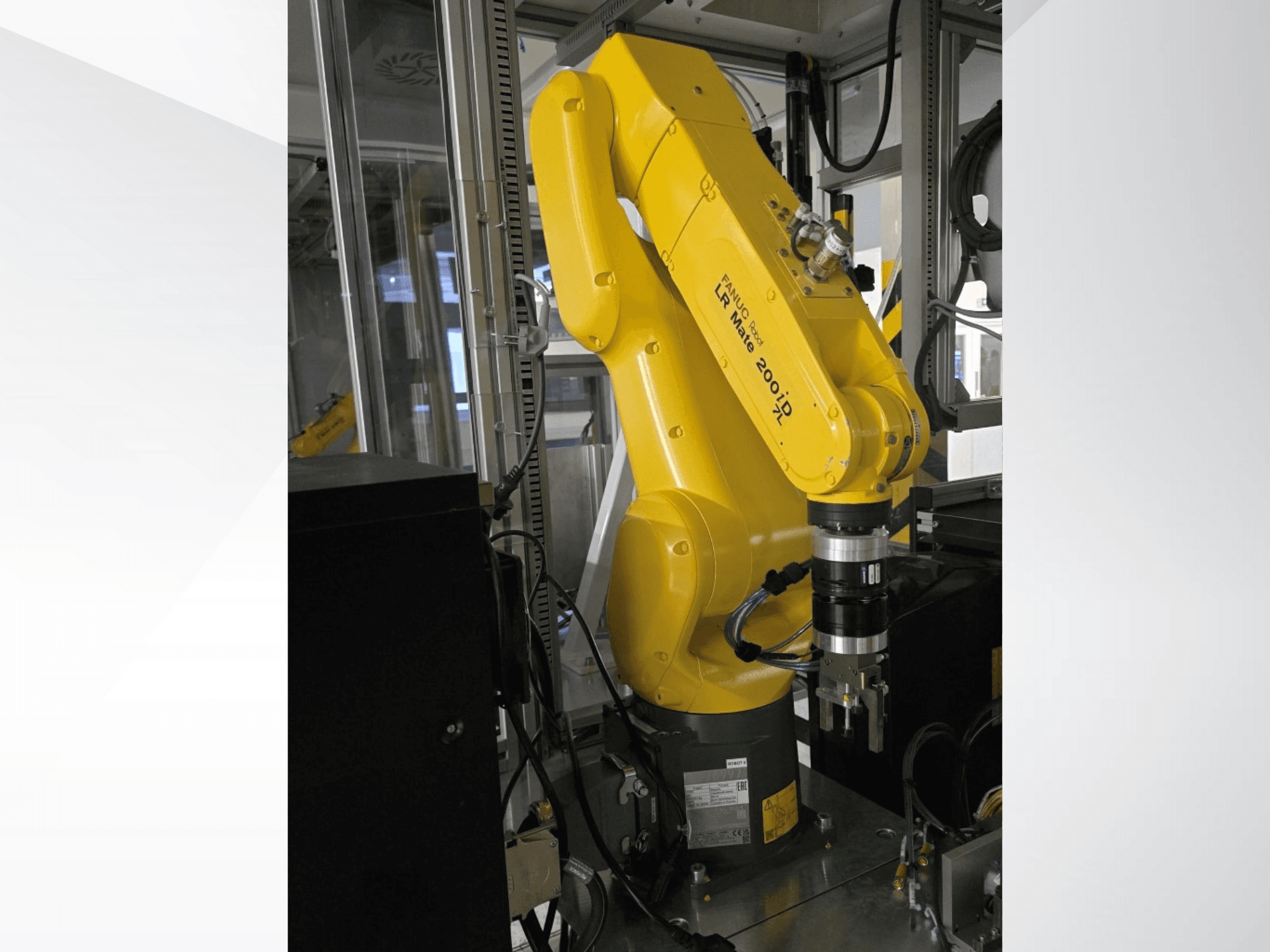 Желтый роботизированный манипулятор Fanuc LR Mate 200iD, показанный с бокового ракурса, с захватом и различными кабелями.