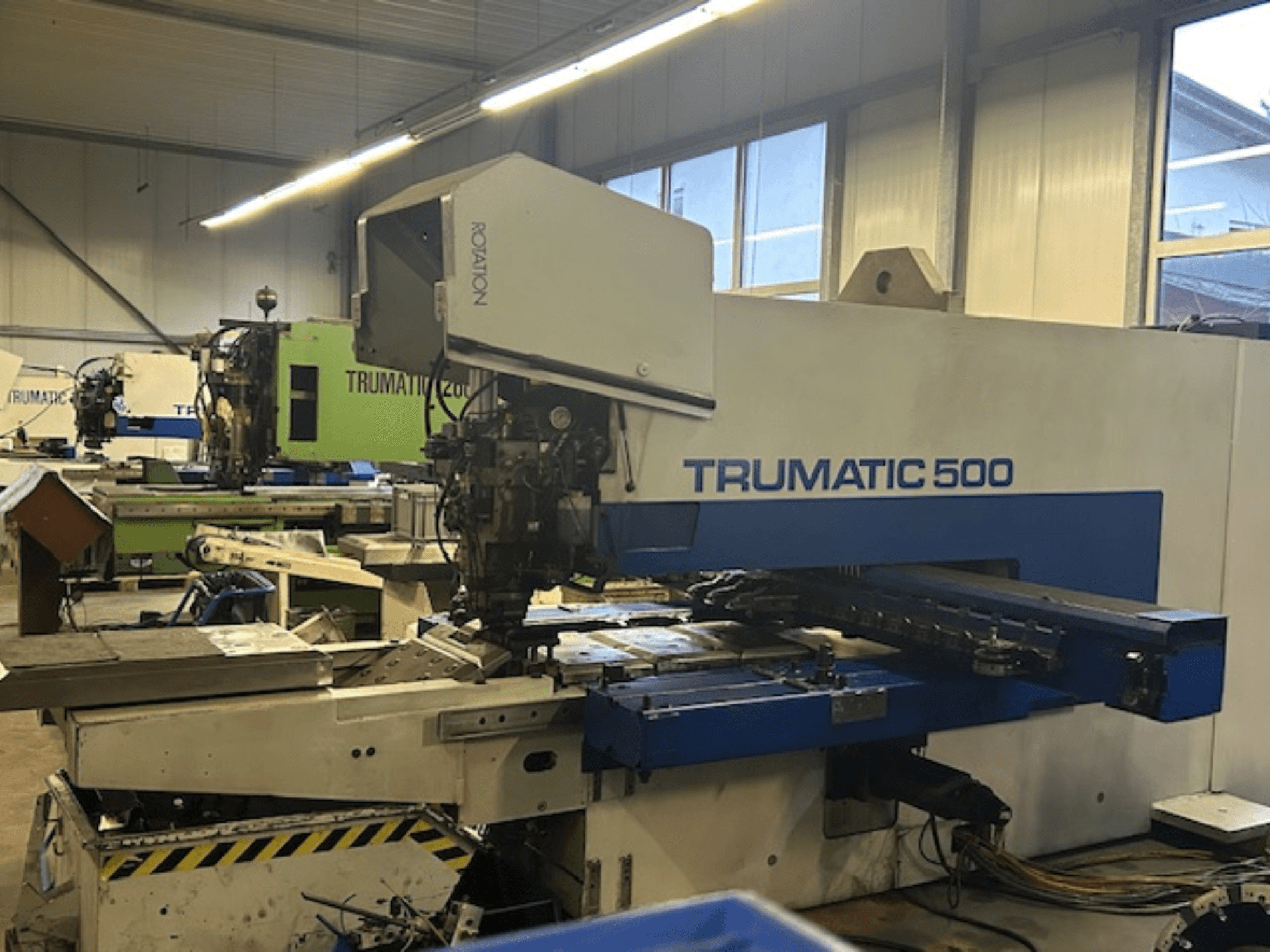 Пробивной станок с ЧПУ TRUMPF TRUMATIC 500, вид спереди, панель управления и механические части. Промышленная мастерская.
