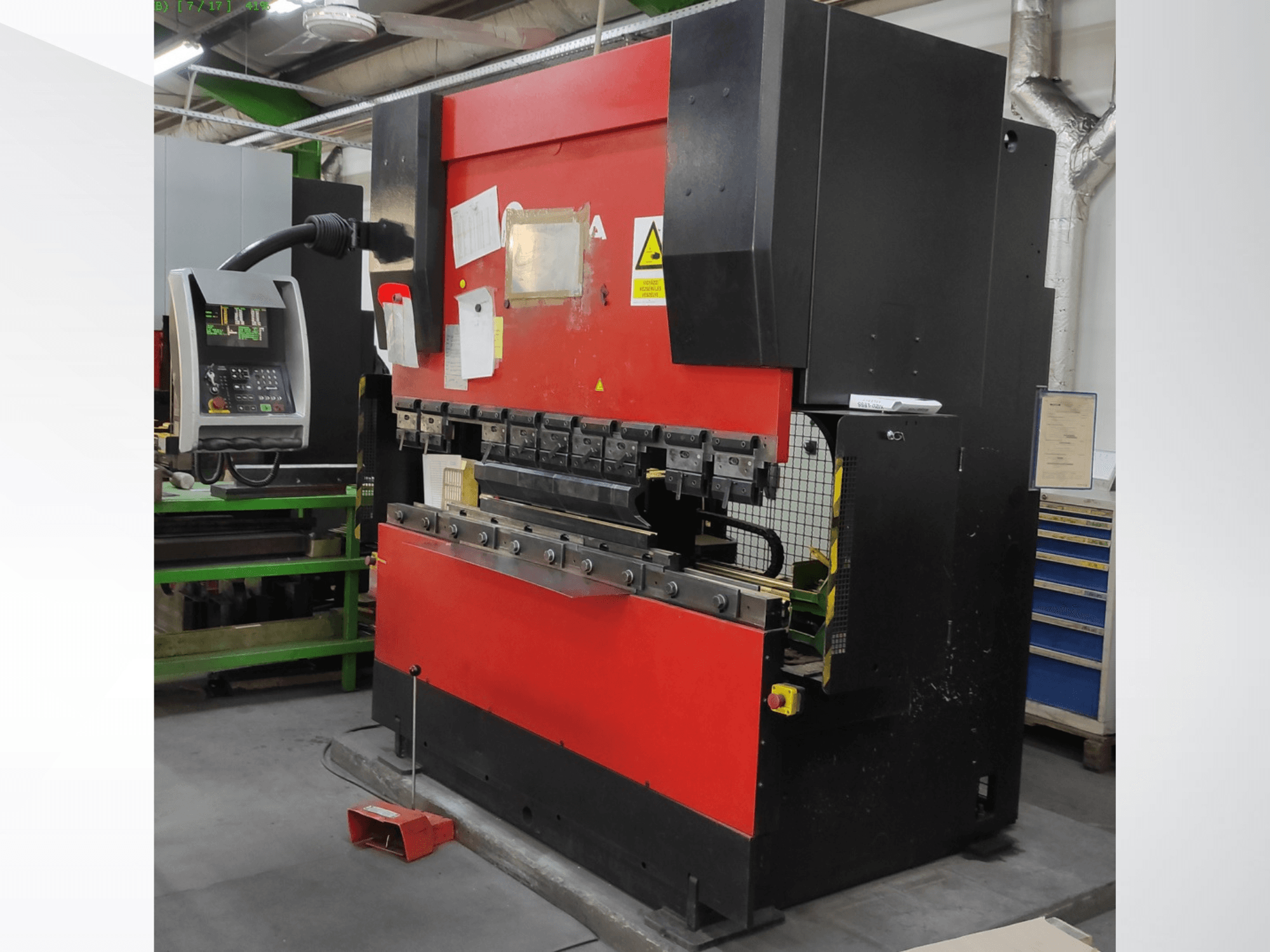 Листогибочный пресс AMADA HFB 5020 в красно-черном исполнении, вид спереди, панель управления, гибочные инструменты и элементы безопасности.