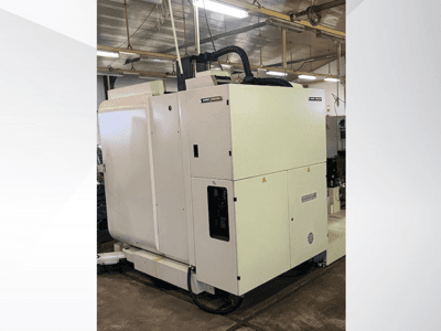 Белый промышленный станок с ЧПУ с видом спереди, с панелью управления и вентиляцией, в мастерской.