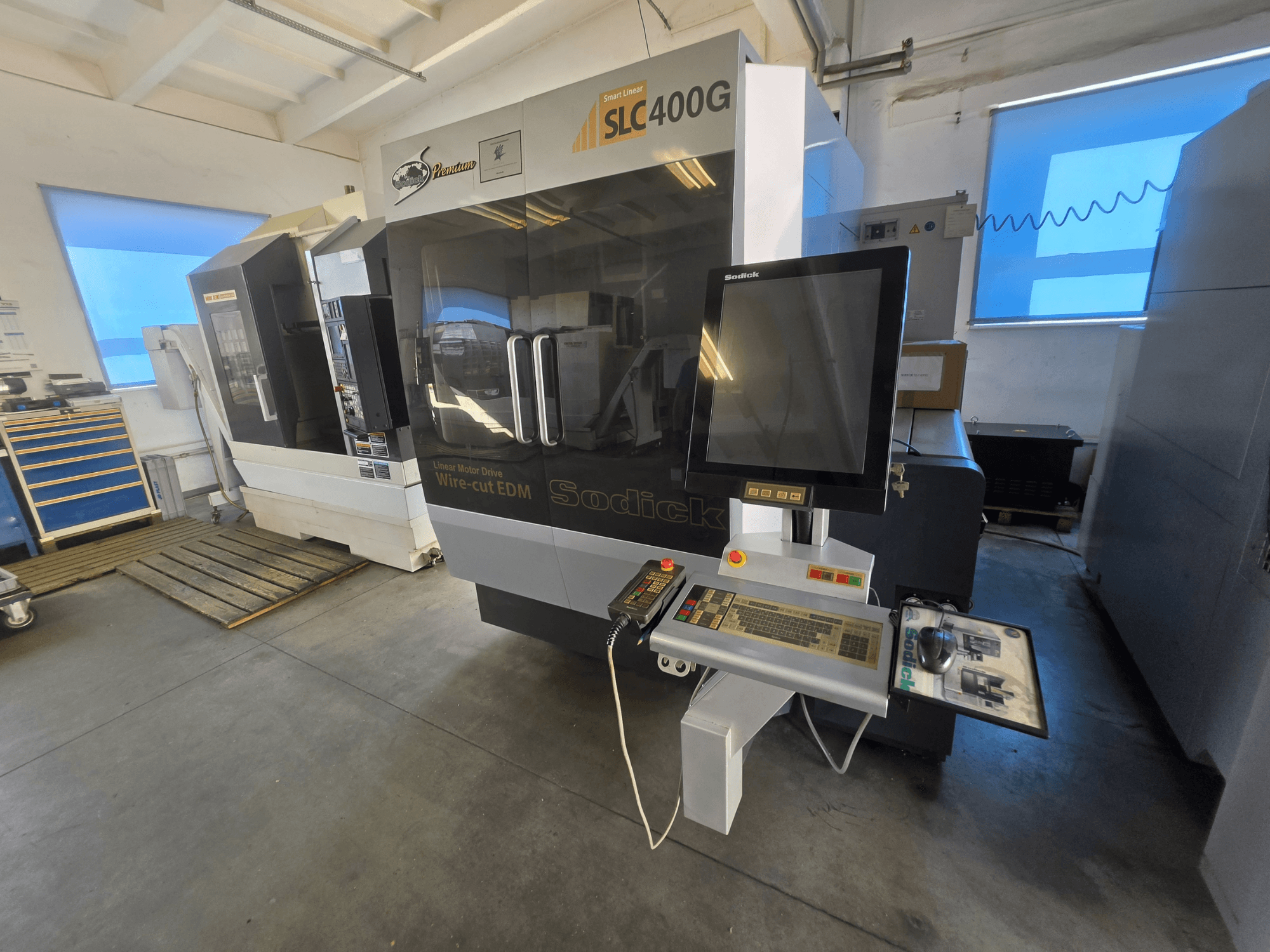 Электроэрозионный станок Sodick SLC400G, вид спереди с панелью управления и сенсорным дисплеем в условиях цеха.