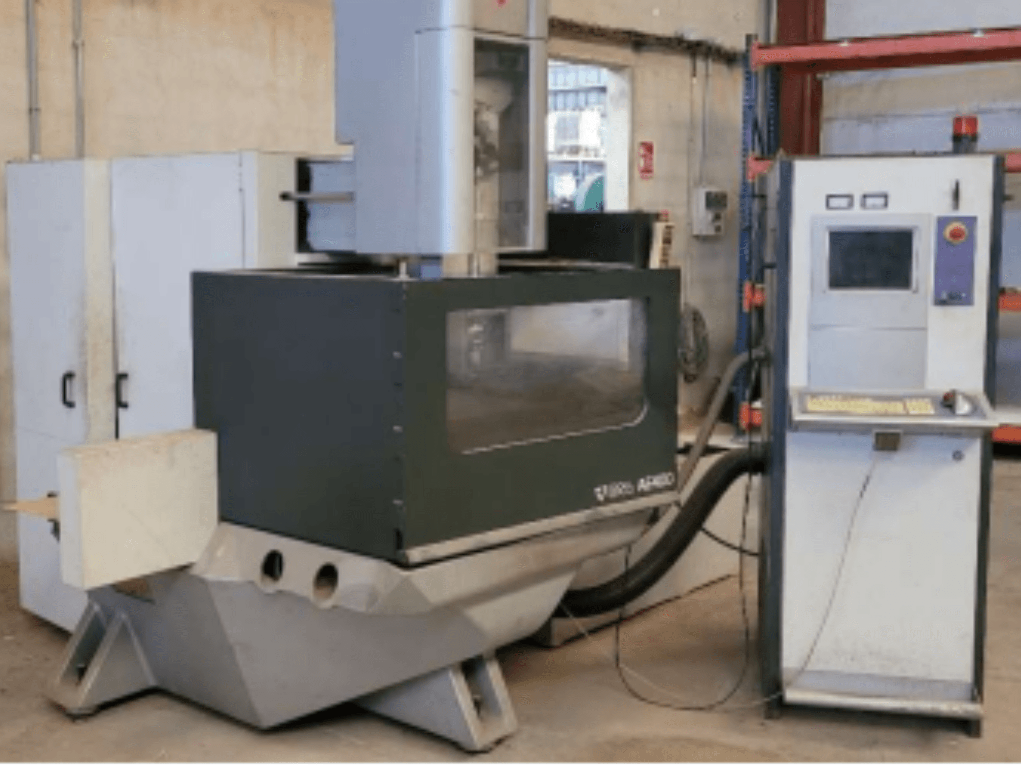 Проволочно-вырезной станок ONA AE 400 в мастерской, с панелью управления справа и большой зоной резки.