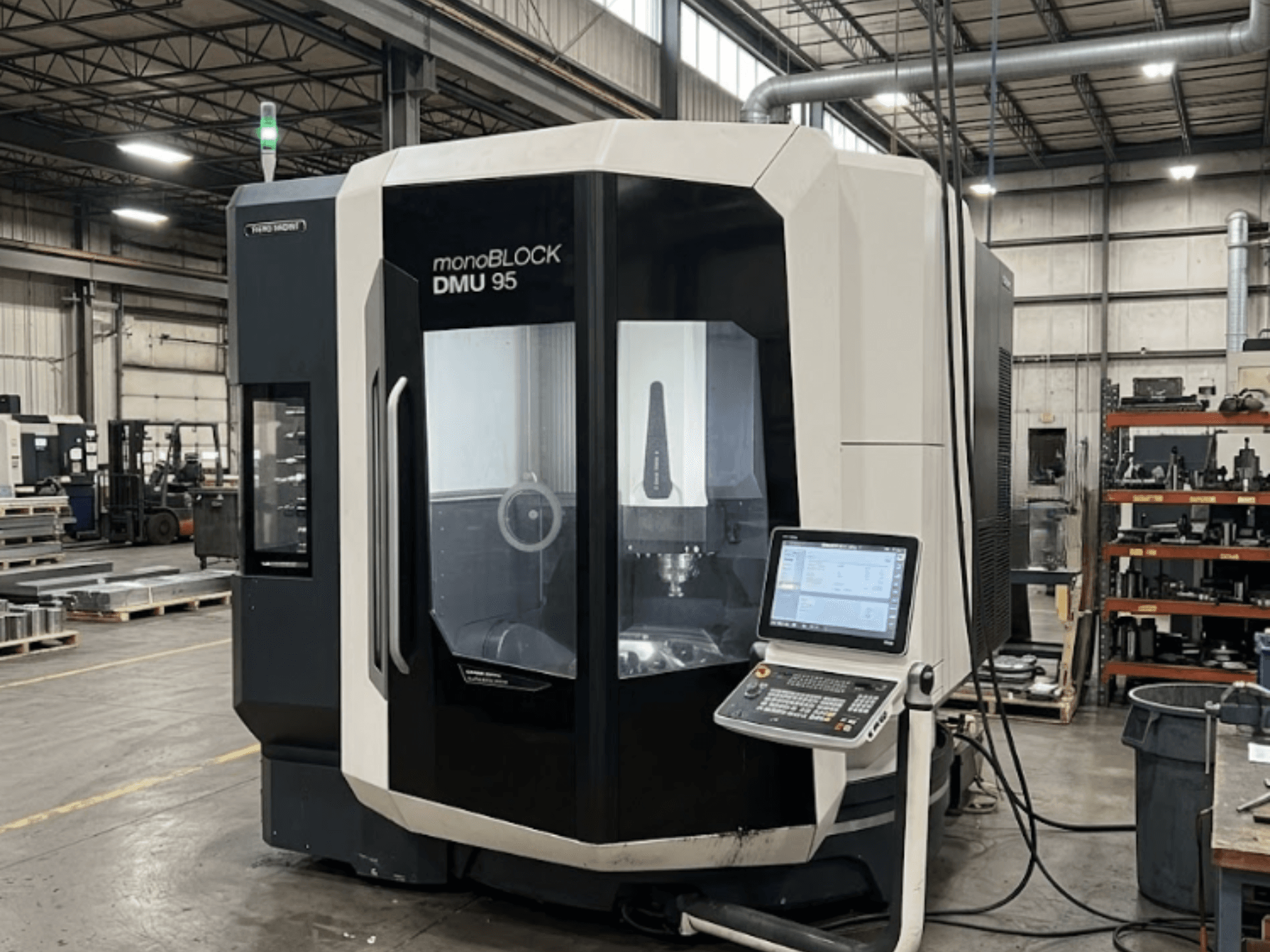Вертикальный обрабатывающий центр DMG MORI DMU 95 Monoblock на заводе с видимой панелью управления, вид спереди.
