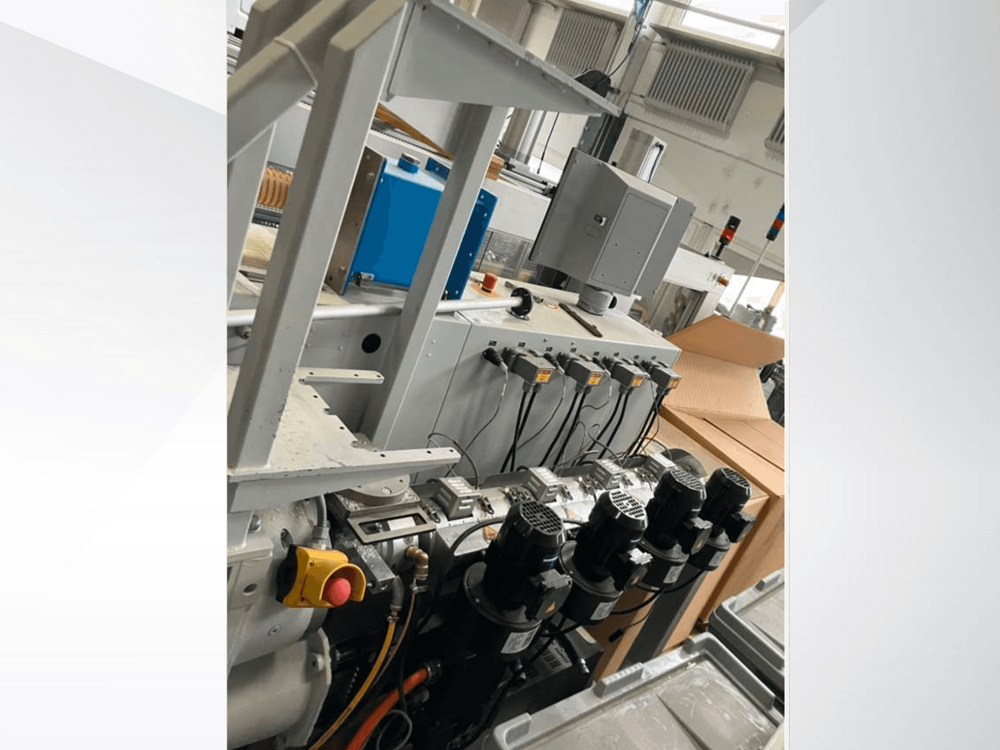 Панель управления промышленным оборудованием с несколькими двигателями, манометрами и монитором; вид сбоку в заводских условиях.