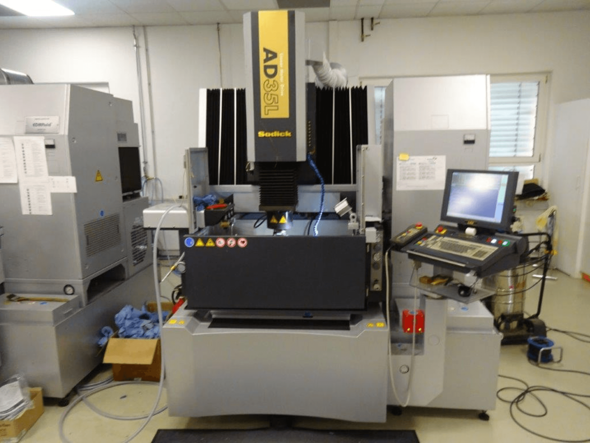 Электроэрозионный станок Sodick AD35L, вид спереди, видны панель управления, система охлаждения и рабочая зона.