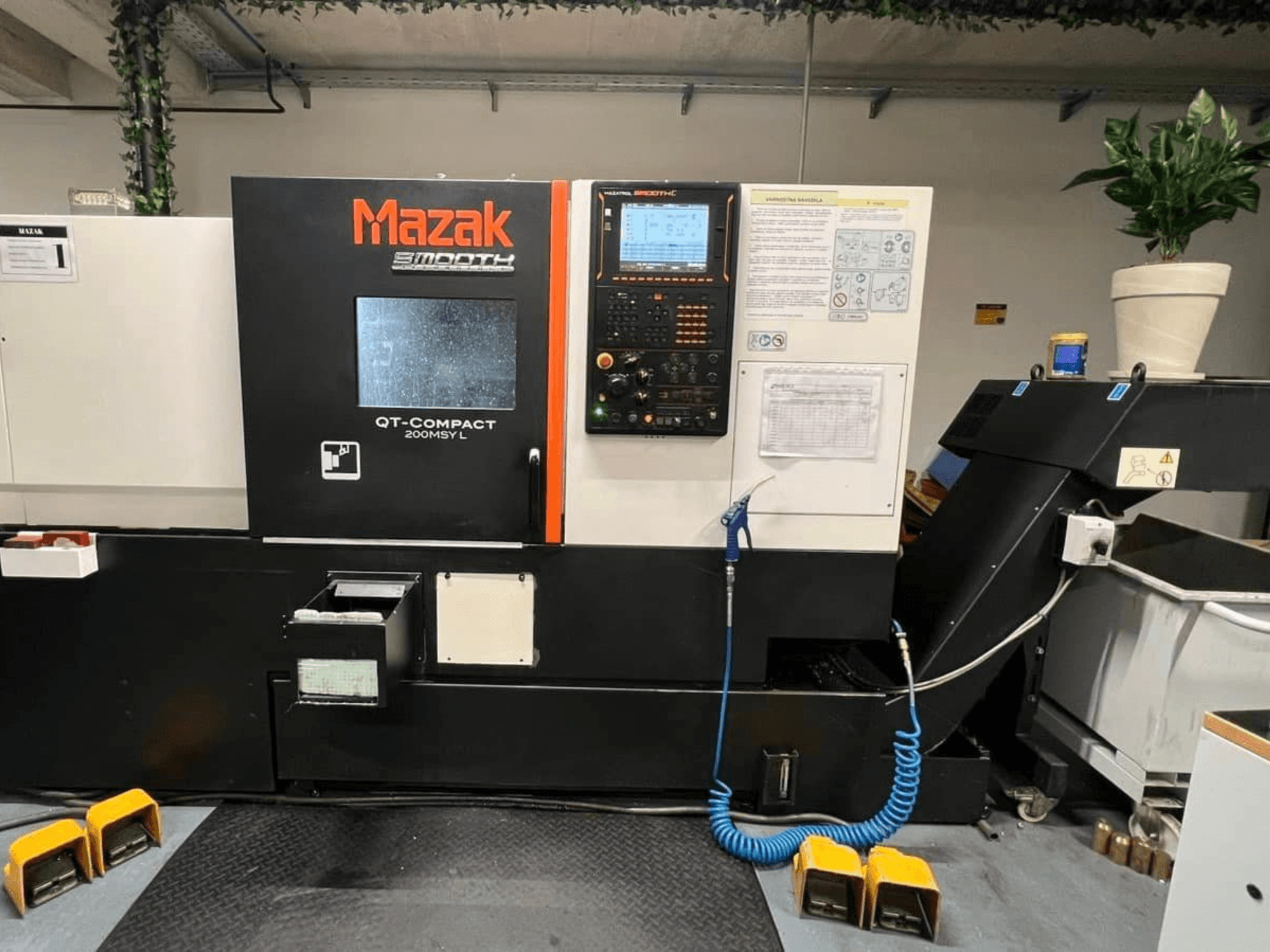 Горизонтальный токарный станок Mazak QUICK TURN COMPACT 200 MSY L, вид спереди, с панелью управления и отсеком для хранения инструментов.