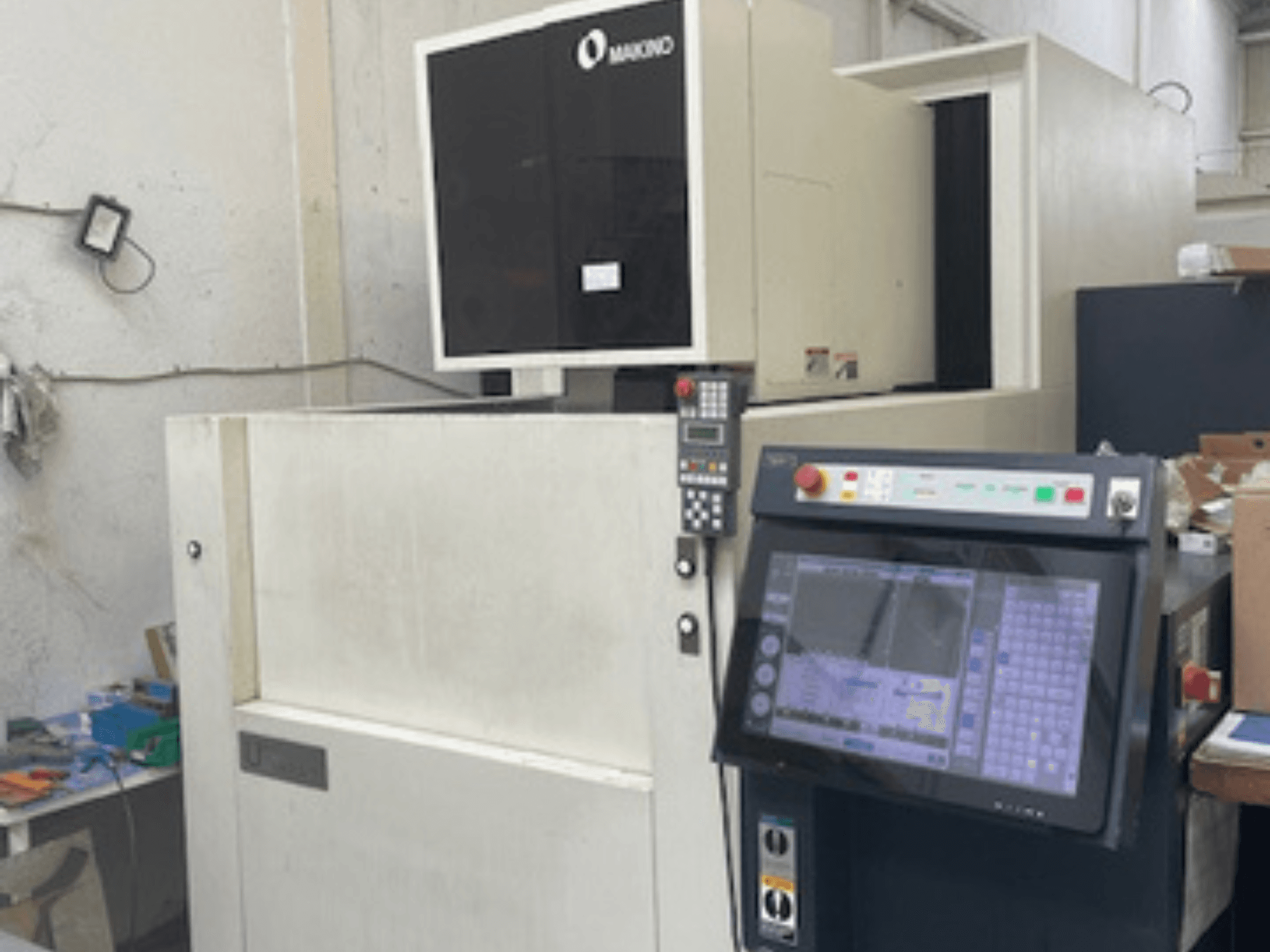 Проволочно-вырезной станок Makino U6 HEAT в мастерской, вид спереди на панель управления и цифровой дисплей.