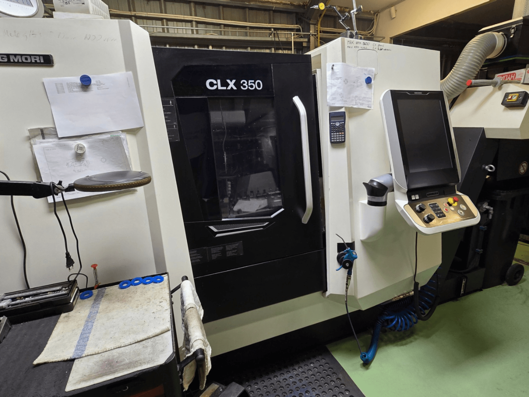 Токарный станок с ЧПУ DMG MORI CLX 350 в мастерской; вид спереди, видны панель управления, инструменты и рабочее пространство.