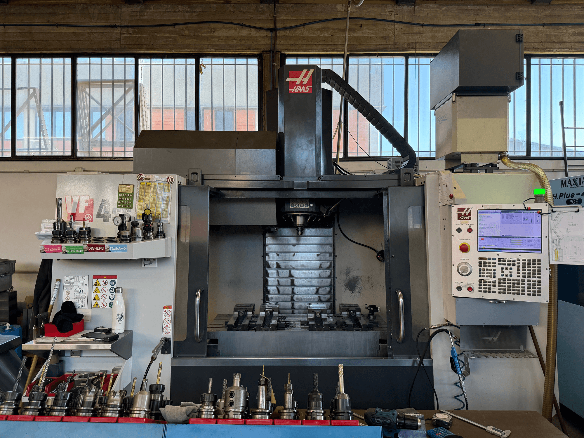 Вертикальный обрабатывающий центр HAAS VF-4SS, вид спереди, на котором видны панель управления, держатели инструментов и область шпинделя.