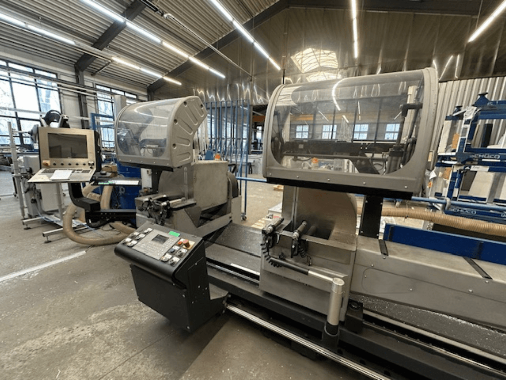 Циркулярная пила по металлу SCHÜCO PDG E CUT, вид спереди, панель управления, защитные кожухи и зона резки в мастерской.