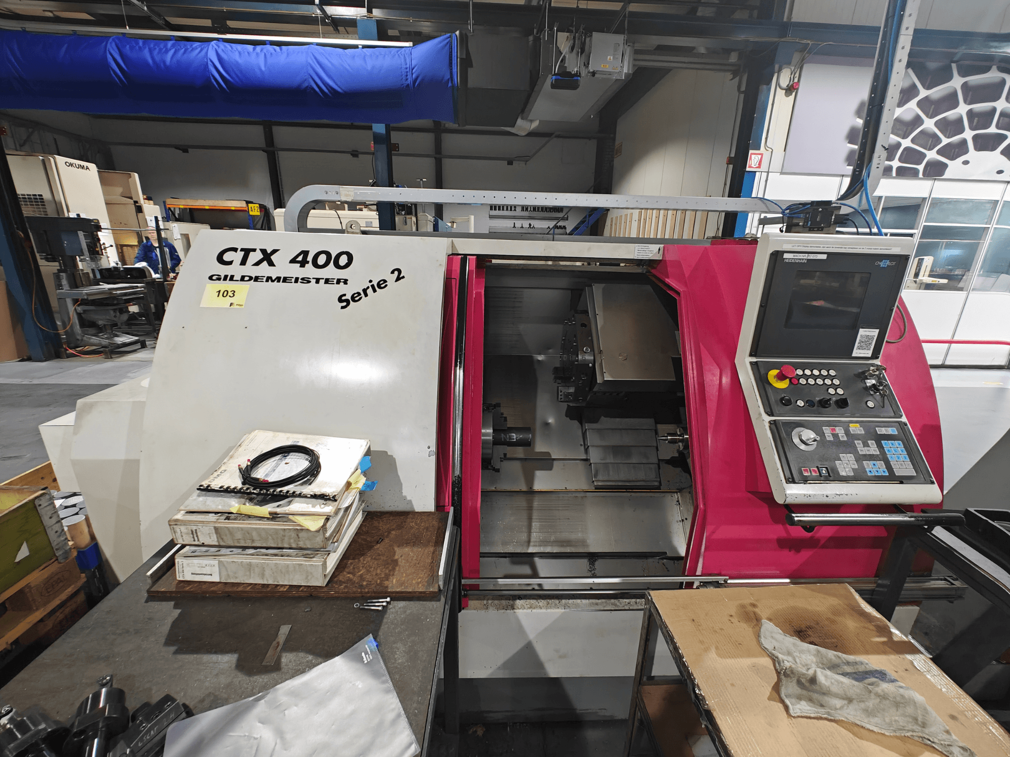 Токарный станок CTX 400 Gildemeister, показанный спереди, имеет панель управления с кнопками, дисплей и рабочую зону.