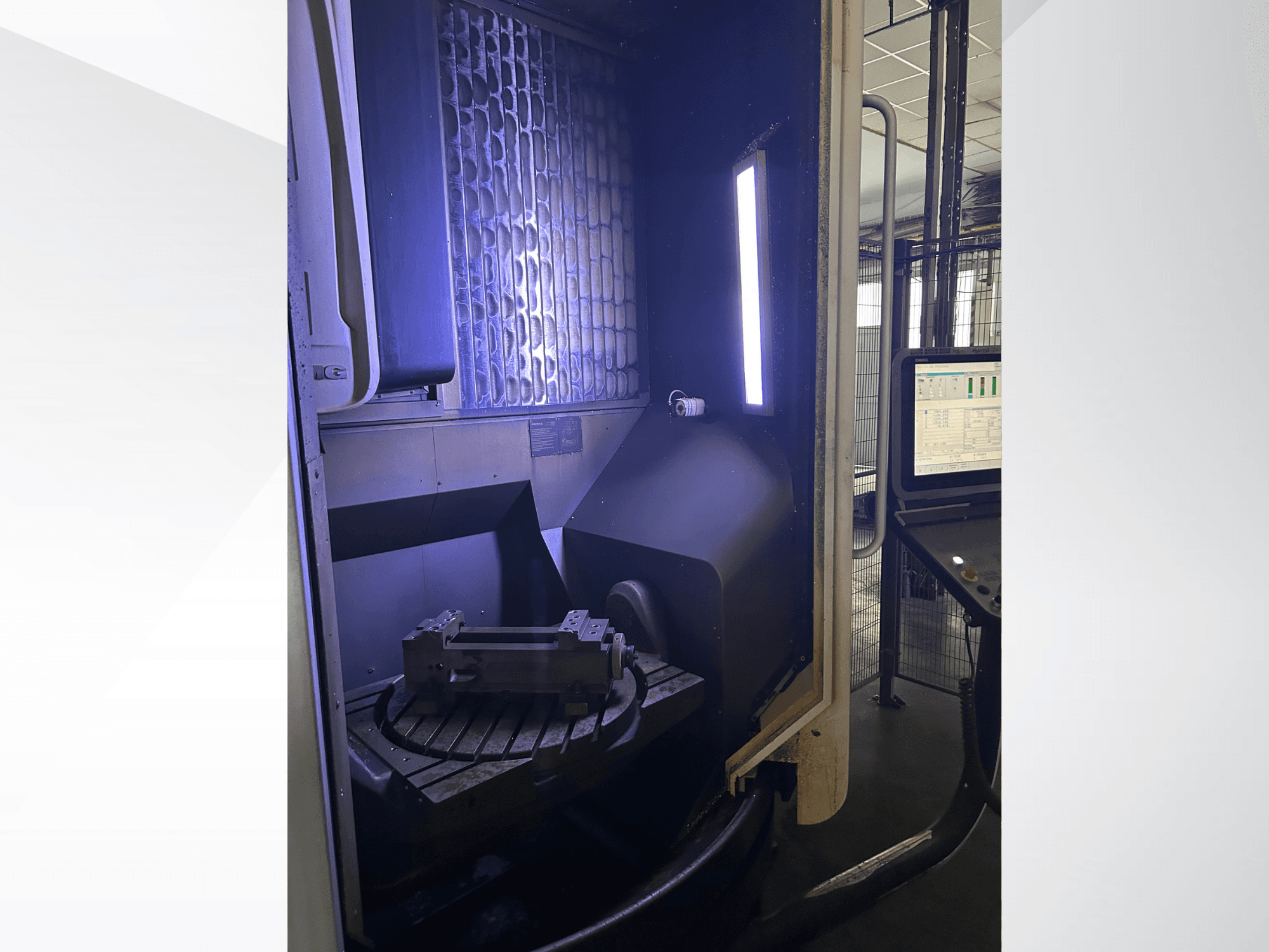 Вертикальный обрабатывающий центр DMG MORI DMU 65 MonoBlock, вид спереди, на котором виден поворотный стол с заготовкой и панель управления.