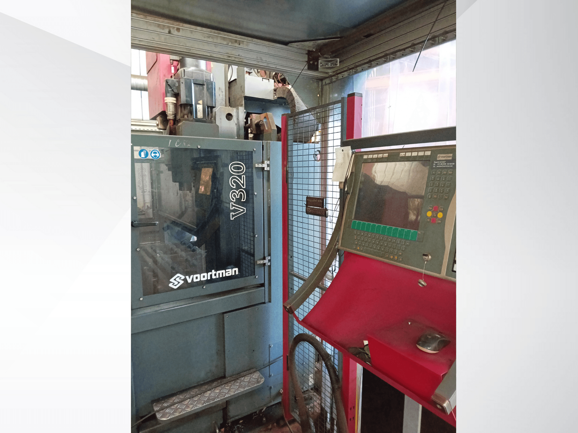 Вид спереди станка с ЧПУ Voortman V320, панель управления с кнопками, экран дисплея и защитный сетчатый кожух.