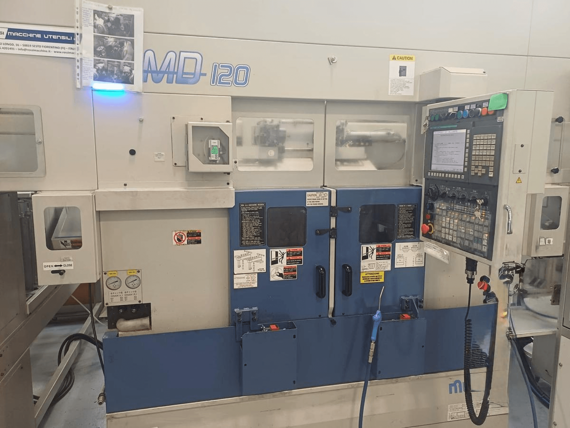 Горизонтальный токарный станок MURATEC MD 120, вид спереди с изображением панели управления, двери и манометров.