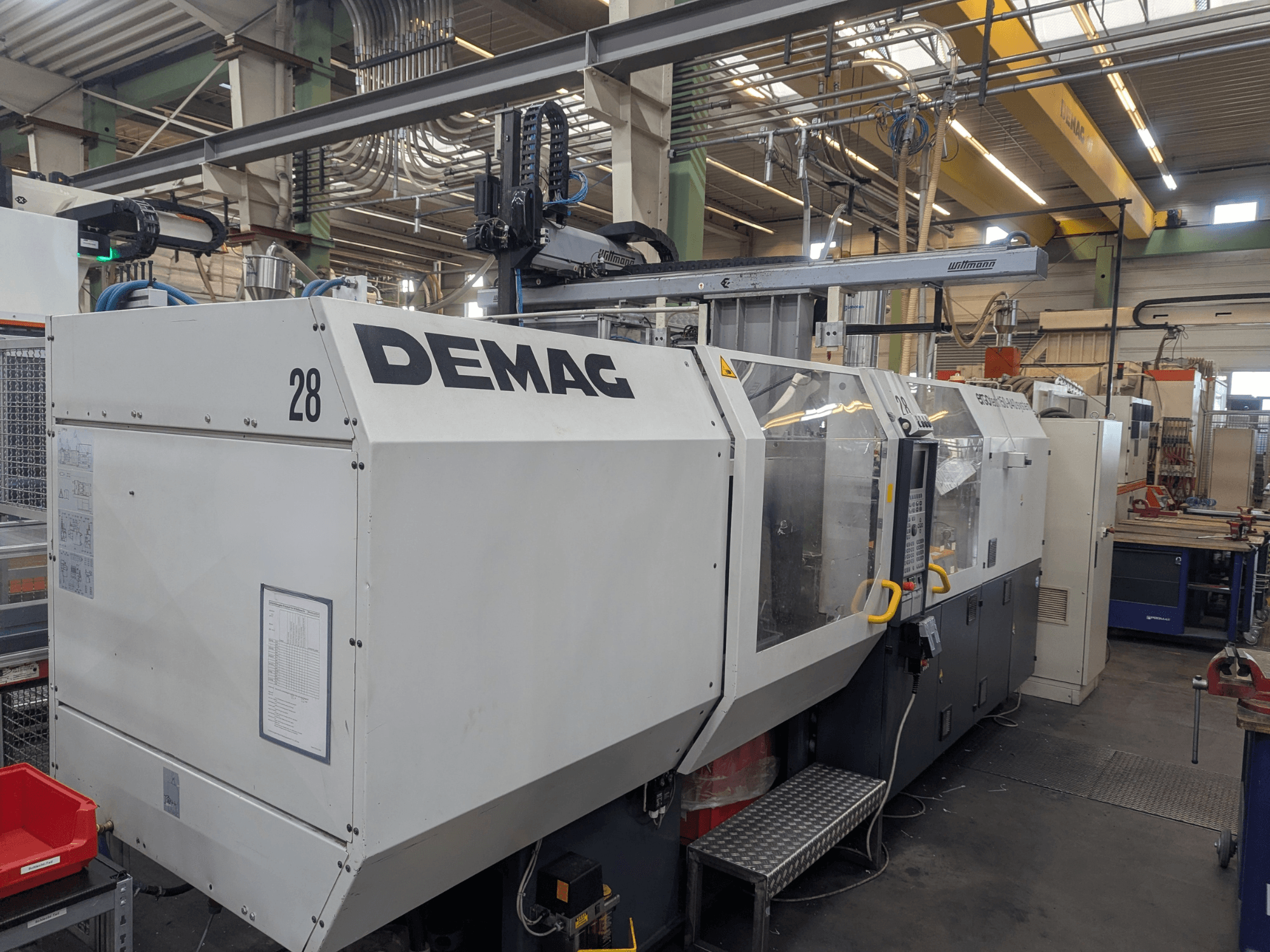Вид спереди гидравлической машины для литья под давлением DEMAG ERGOTECH 1500-840, демонстрирующий органы управления и средства безопасности.