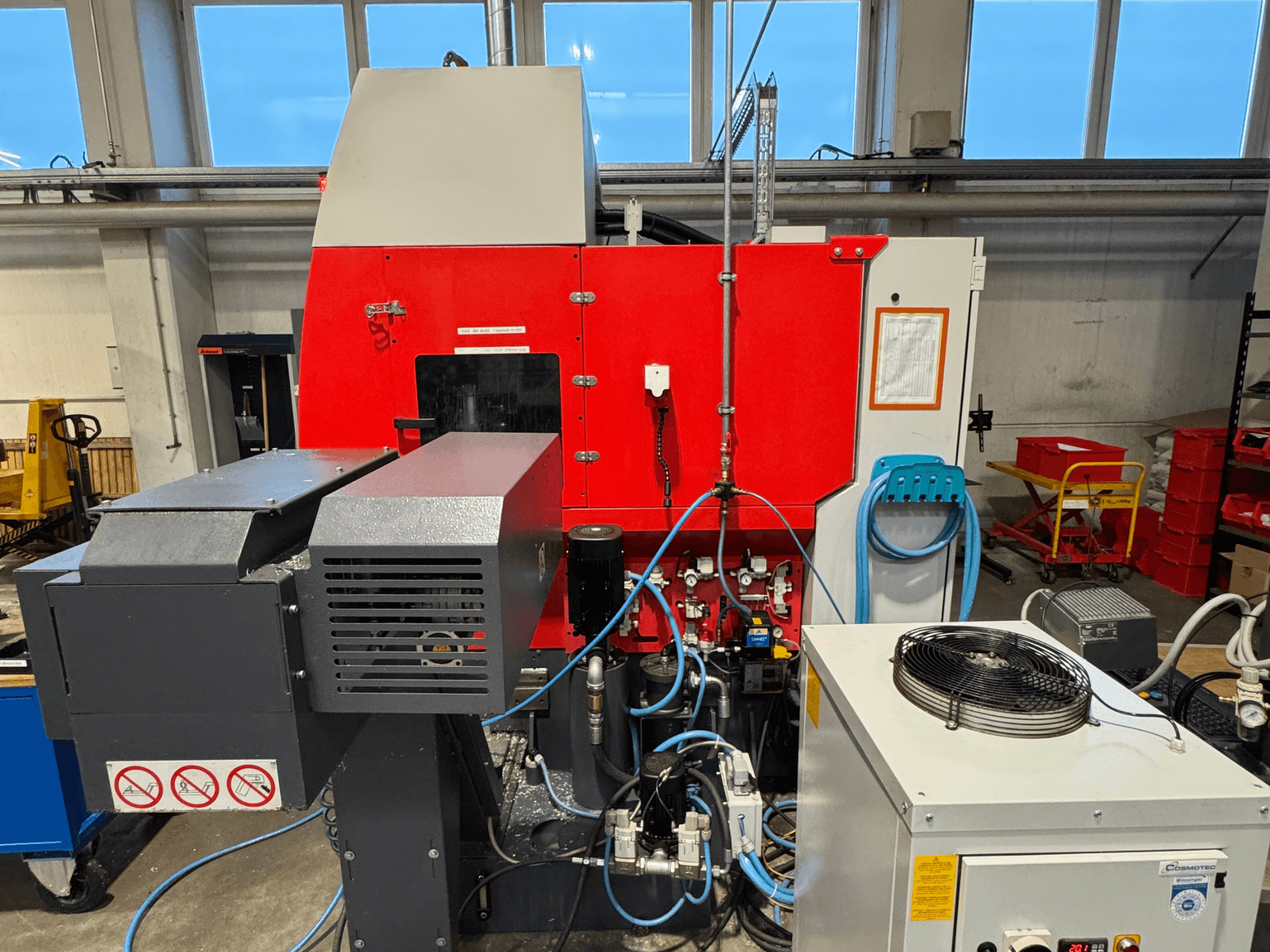 Вертикальный обрабатывающий центр EMCO MAXXMILL 350, вид спереди, демонстрирует сложные механизмы и детали панели управления.