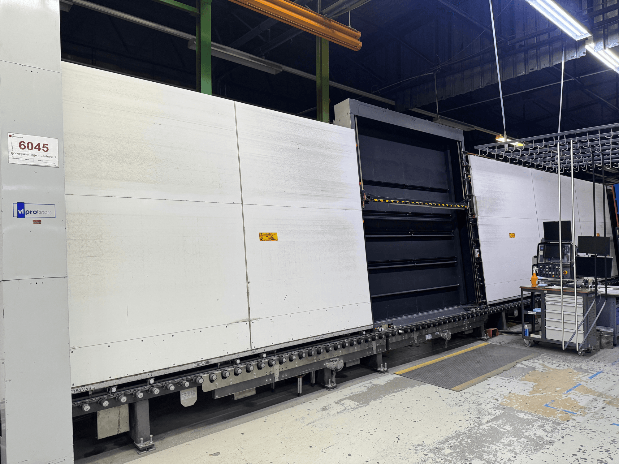 Вид спереди на пресс-форму Vipro с открытой панелью, демонстрирующей рабочее оборудование и рабочее место рядом с ним. Модель 6045.