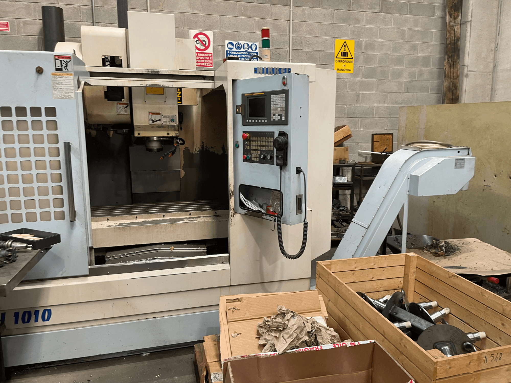 Вертикальный обрабатывающий центр фирмы Other, модель VH-1010, вид спереди, видны органы управления и ящики рядом.