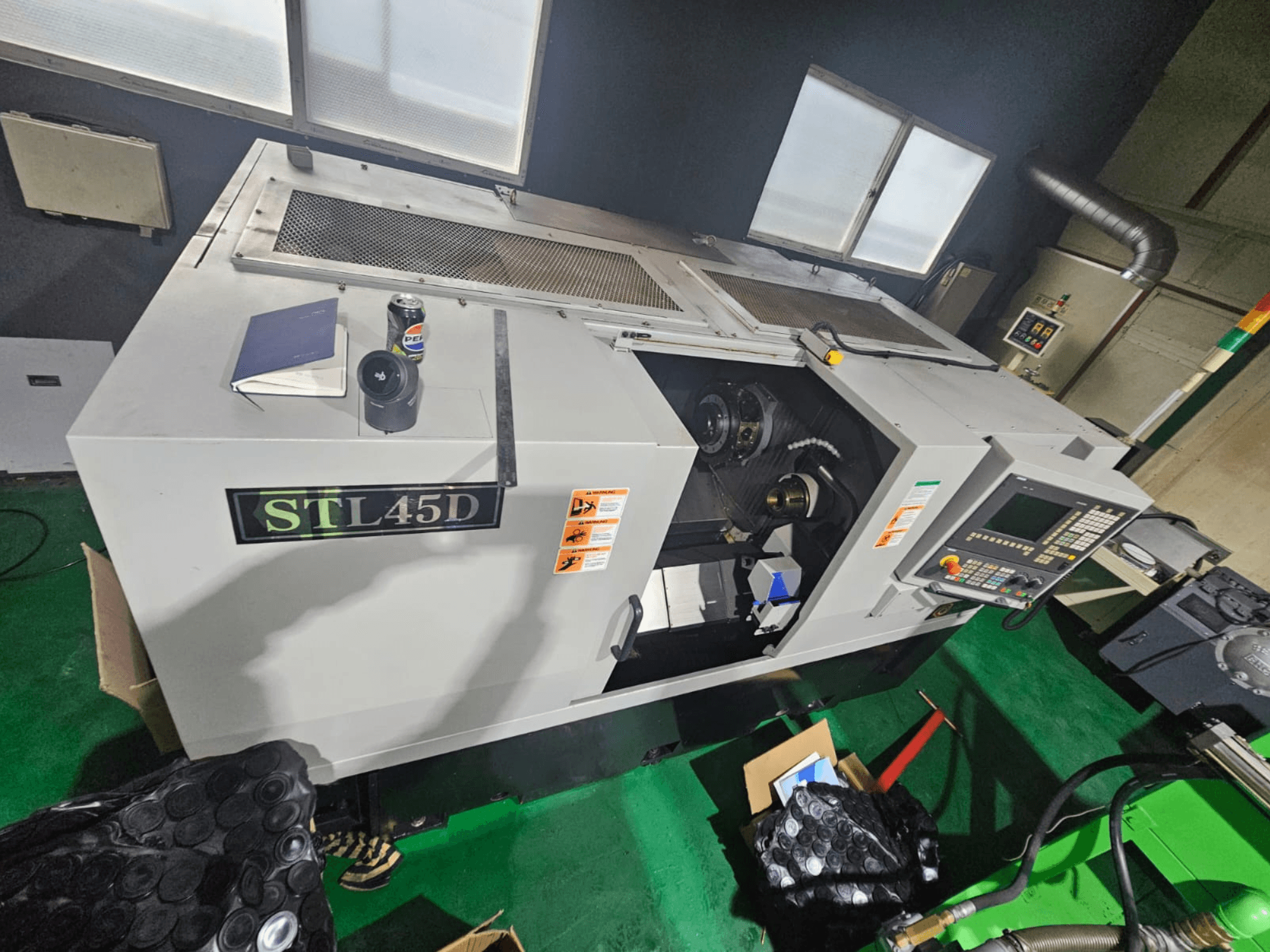 Станок с ЧПУ STL45D, вид сверху, панель управления, цилиндрическая деталь, ноутбук и банка сверху.