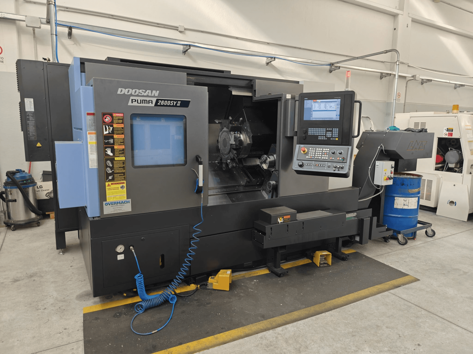 Горизонтальный токарный станок DOOSAN Puma 2600 SY II, вид спереди, с панелью управления и индикаторами рабочего состояния.