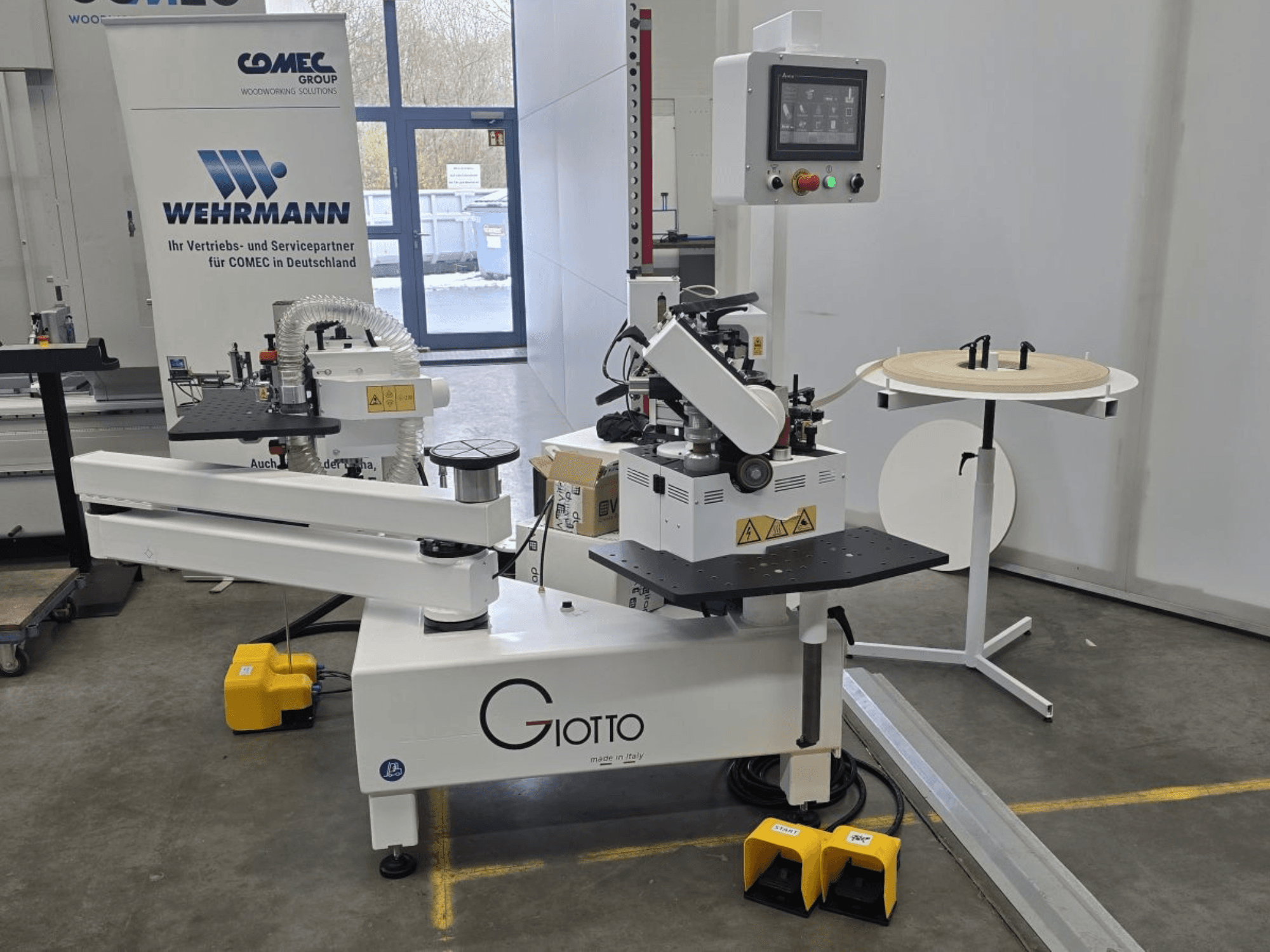 Станок для обработки древесины Giotto с панелью управления, вид сбоку, включает ножные педали и вращающуюся рабочую поверхность.
