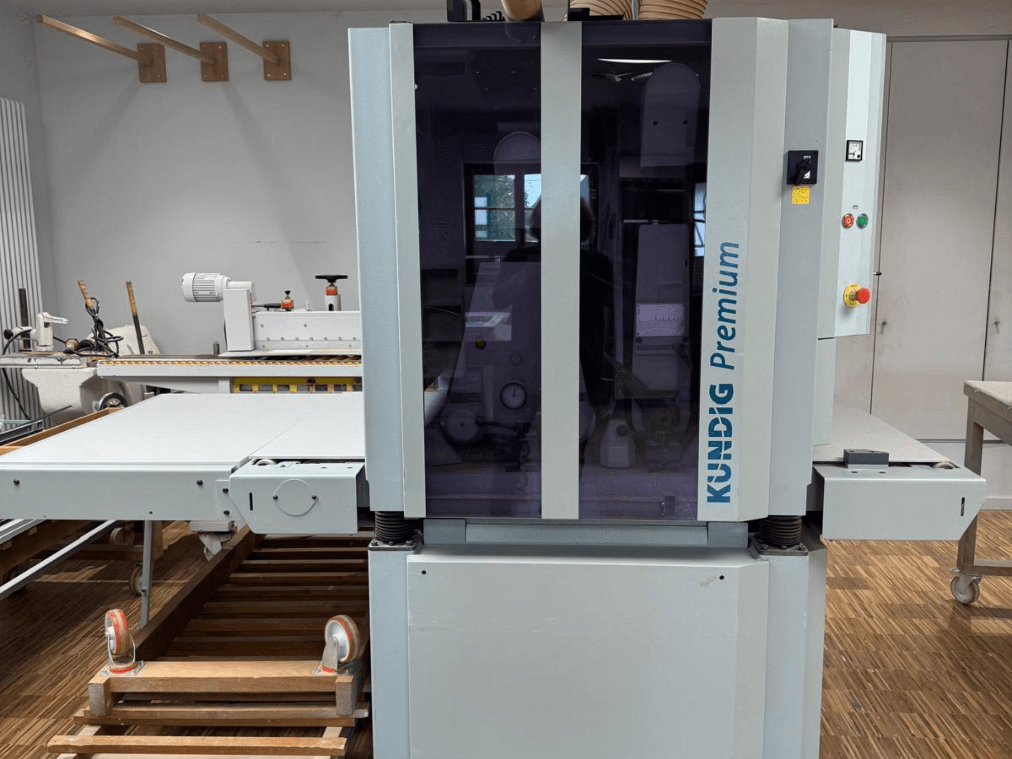 Ленточная шлифовальная машина Kundig Premium 2-1100-RP с видом спереди с панелью управления и большим стеклянным корпусом для обзора.