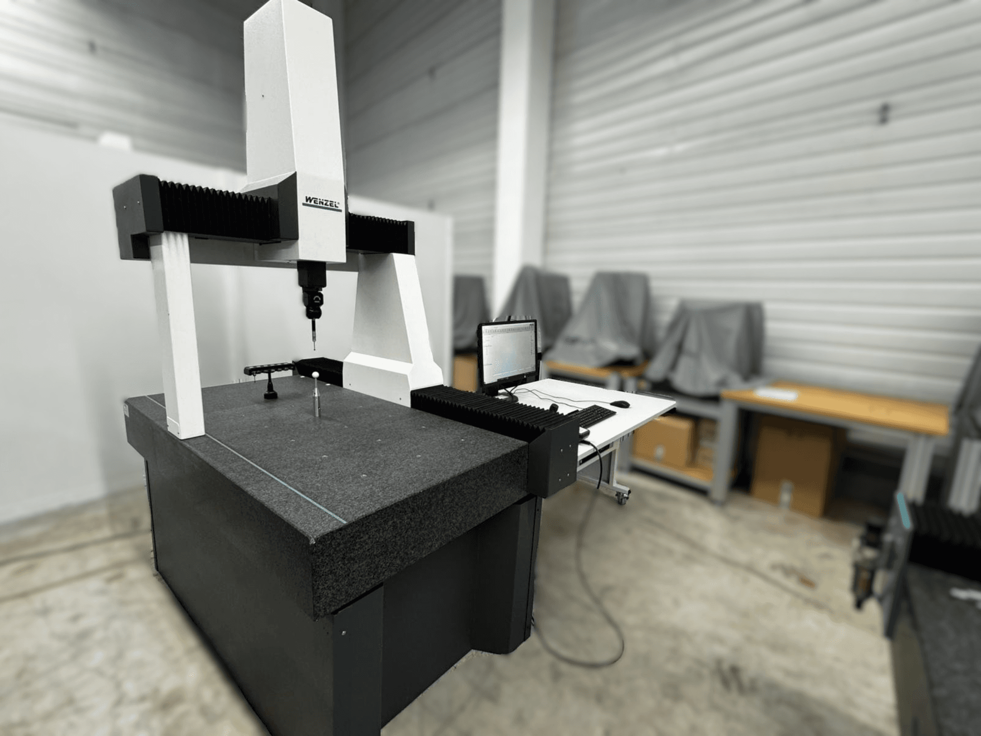 Координатно-измерительная машина Wenzel LH 54 с видом сбоку, с датчиком и компьютерным интерфейсом на сером основании.