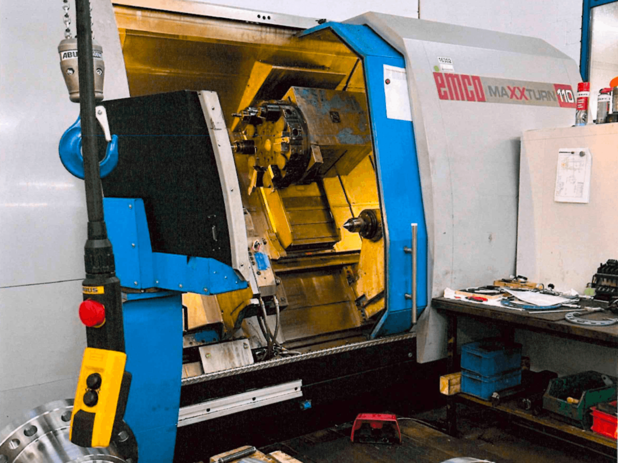 Горизонтальный токарный станок EMCO MAXTURN 110, вид спереди, с видимыми внутренними узлами и панелью управления, в условиях цеха.