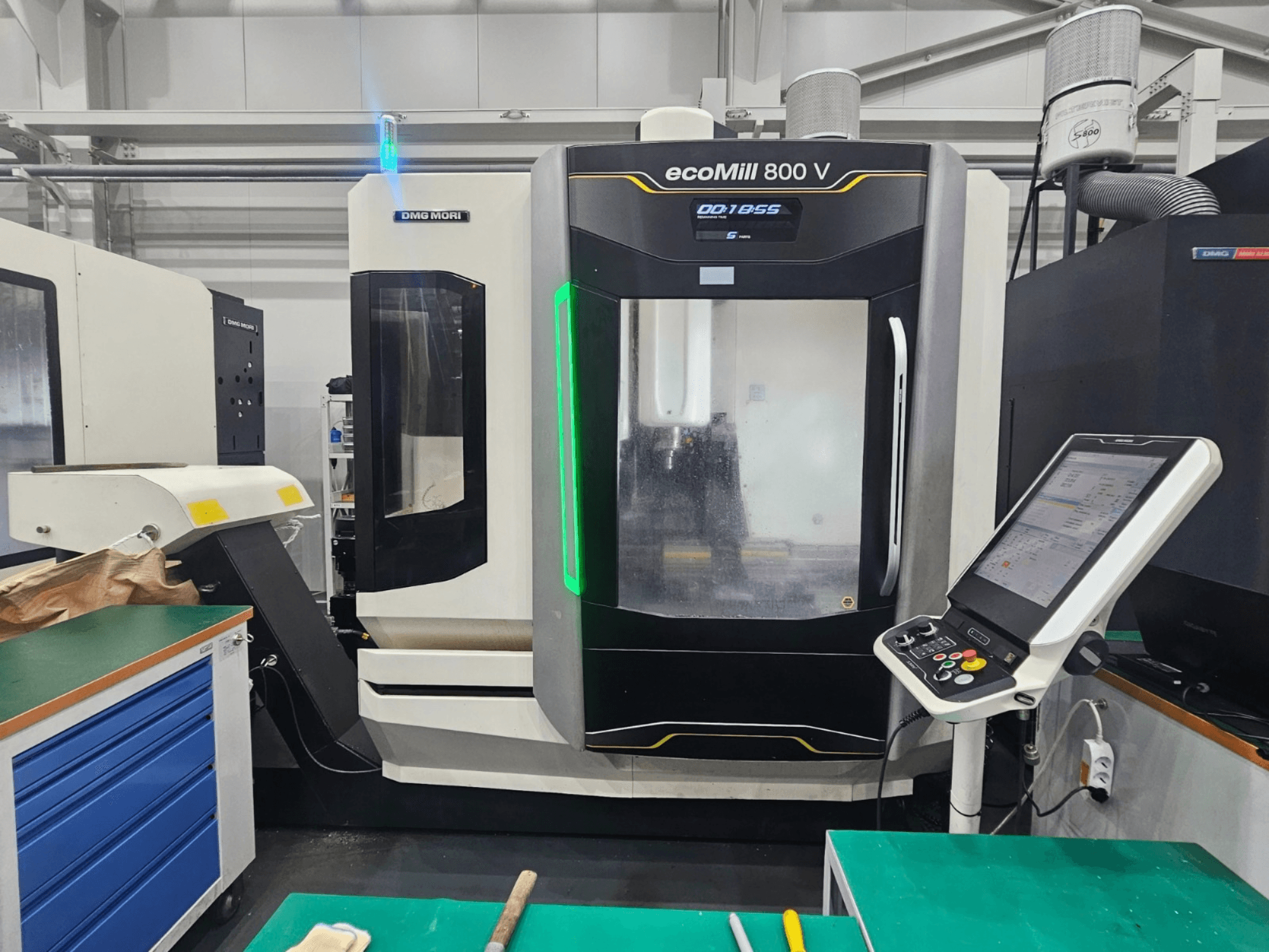 Вертикальный обрабатывающий центр DMG MORI ecoMill 800 V, вид спереди с видимой панелью управления и деталями станка.