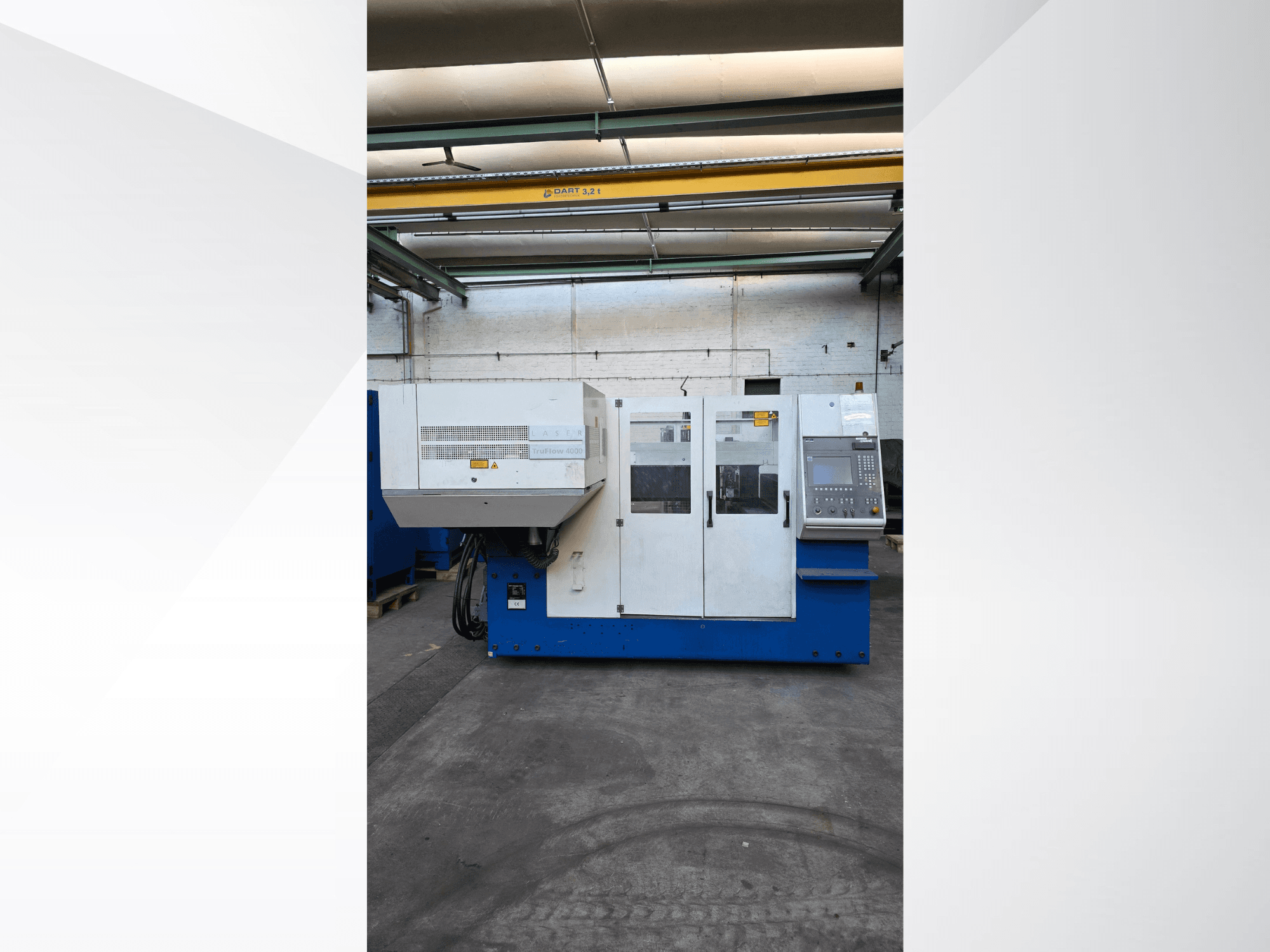 Станок лазерной резки CO2 TRUMPF TruLaser 3030, вид спереди, панель управления и предупреждения о безопасности на внешней стороне.